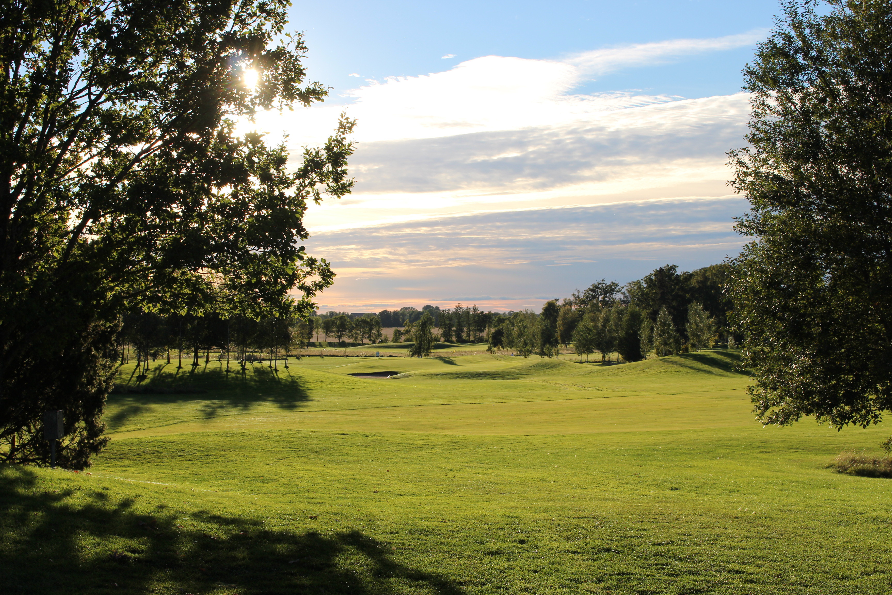 En vacker solig vy ut över en grön golfbana.