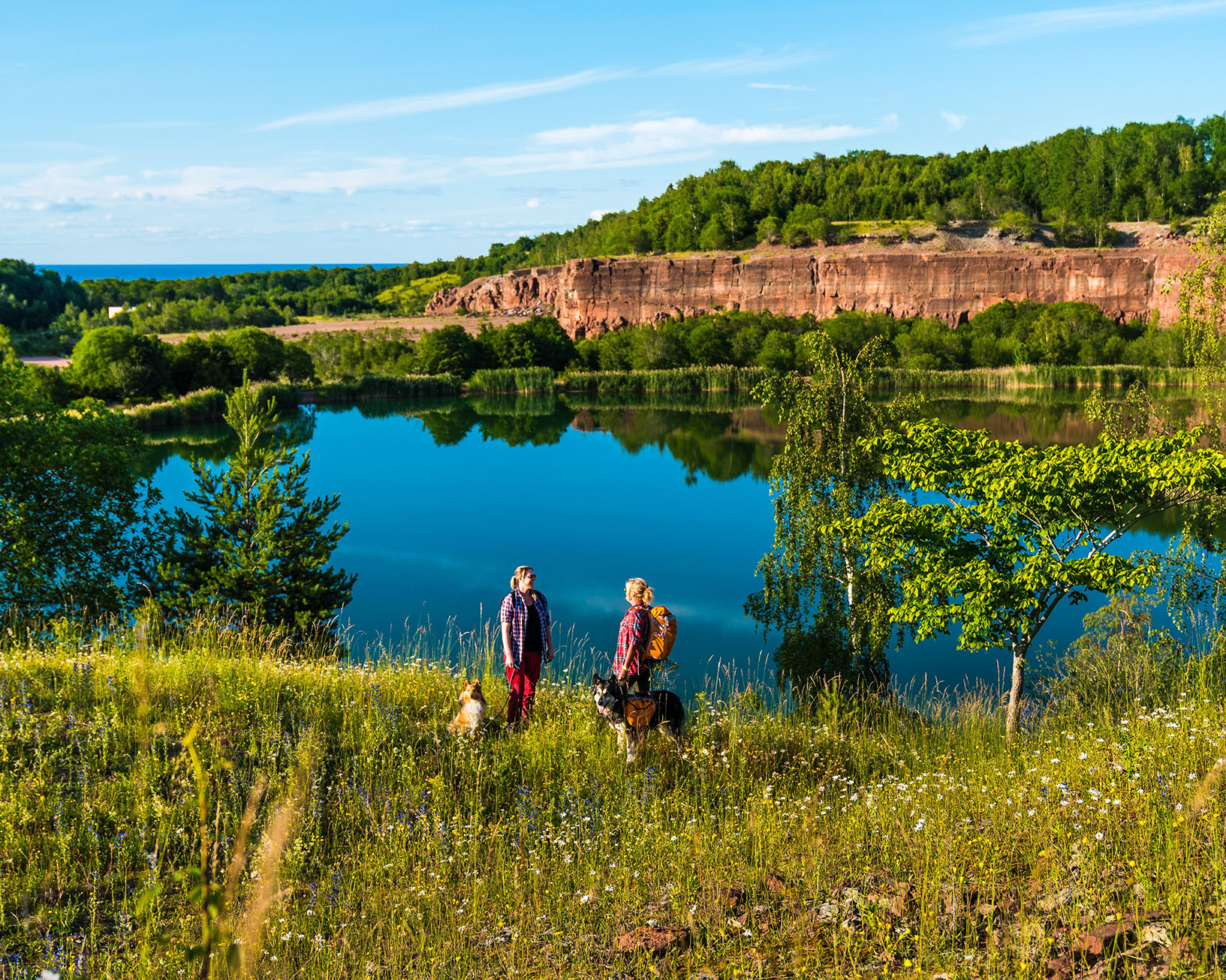 Two women standing in front of an old quarry with a lake.