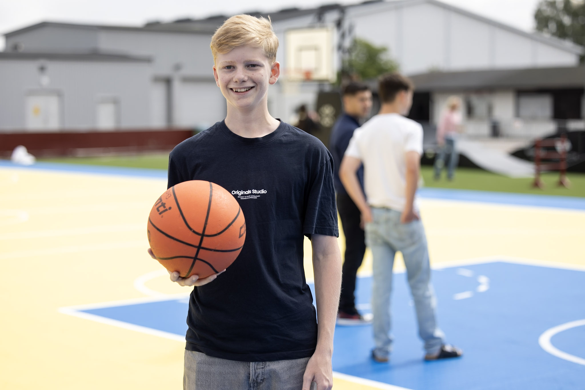Kille står och håller i en basketboll.