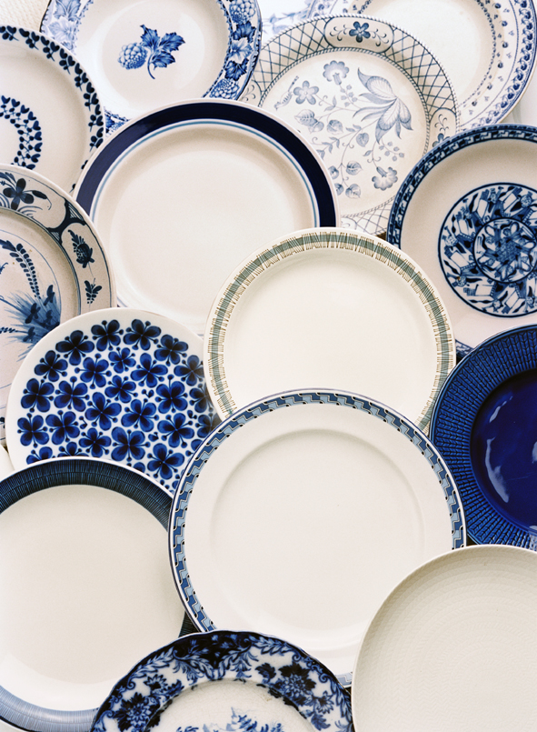 Plates from Rörstrand covering the whole image. They are white and blue, with different patterns.