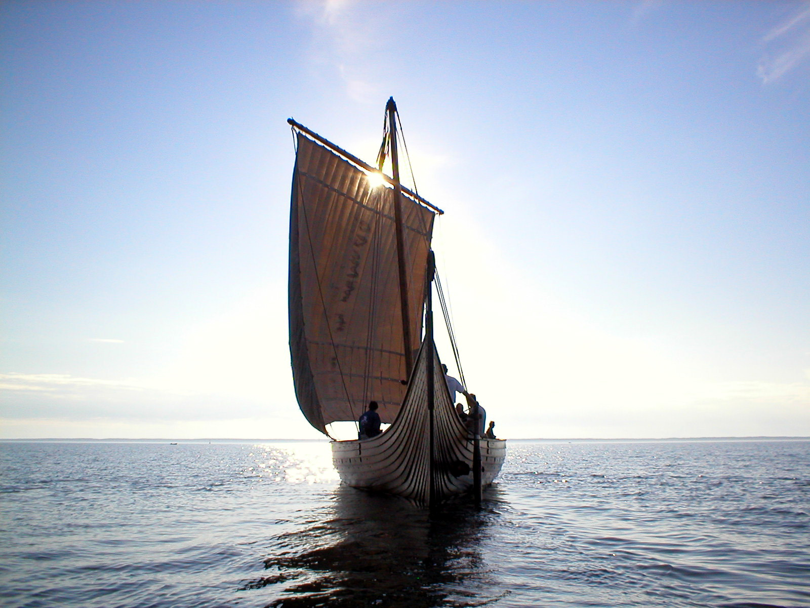 Ett vikingaskepp i kvällssolen på öppet vatten.