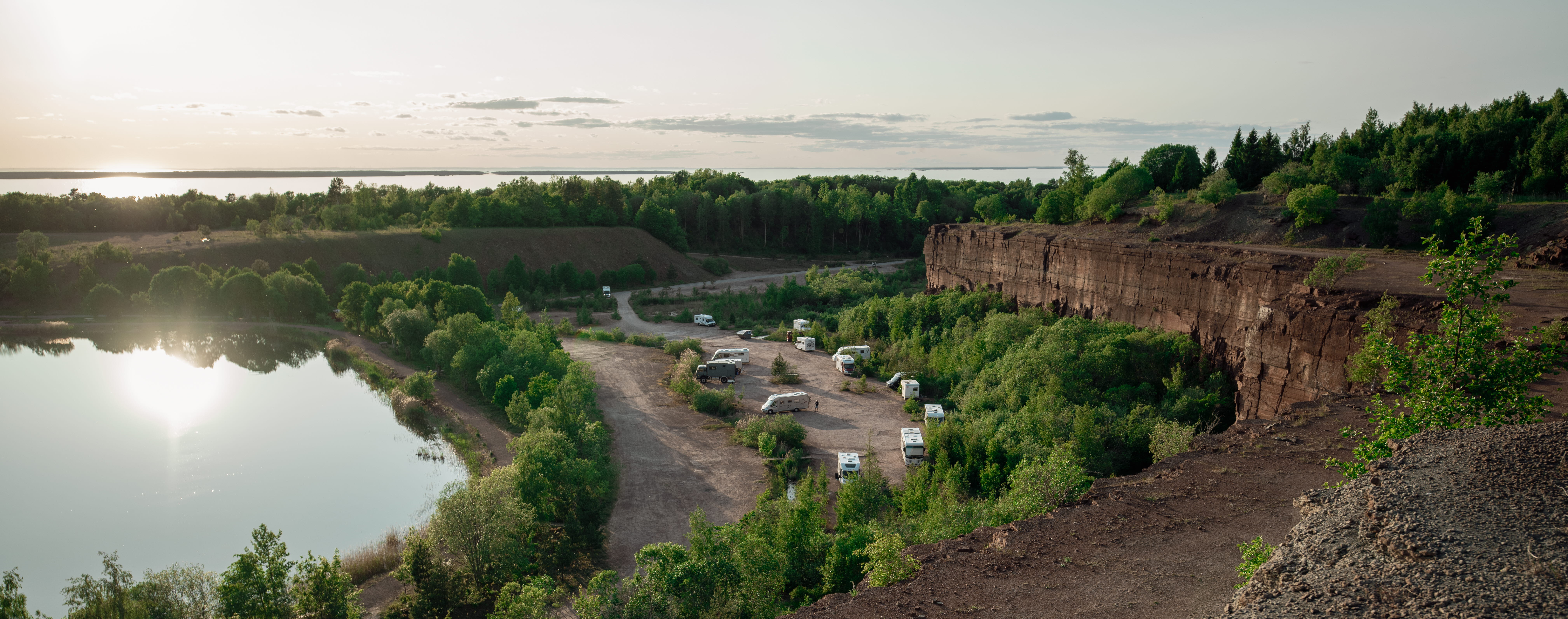 Tre människor promenerar vid Stora Stenbrottet, Kinnekulle med utsikt över Vänern