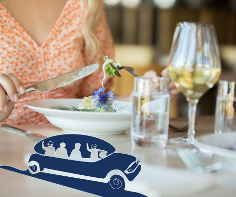 En tallrik och ett glas vin som någon äter ifrån. En illustrerad blå bil på bilden. 