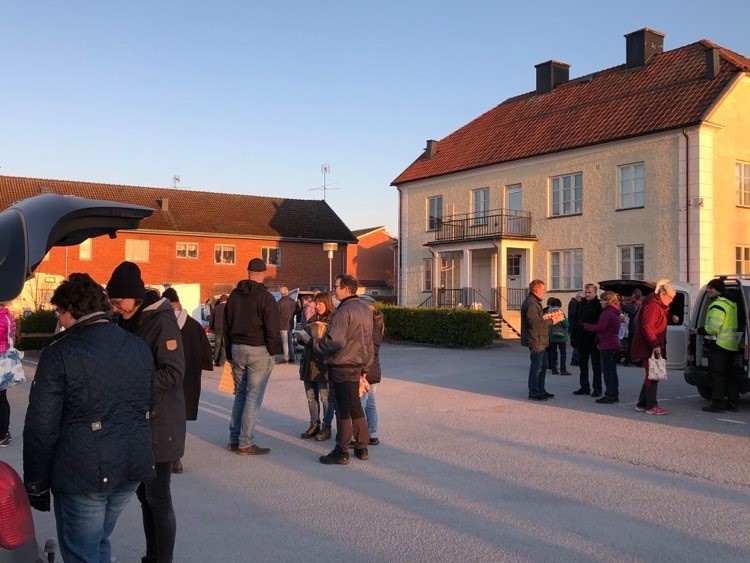 Utlämning av REKO-ringens lokala råvaror. Personer som samlats för att hämta sina varor.