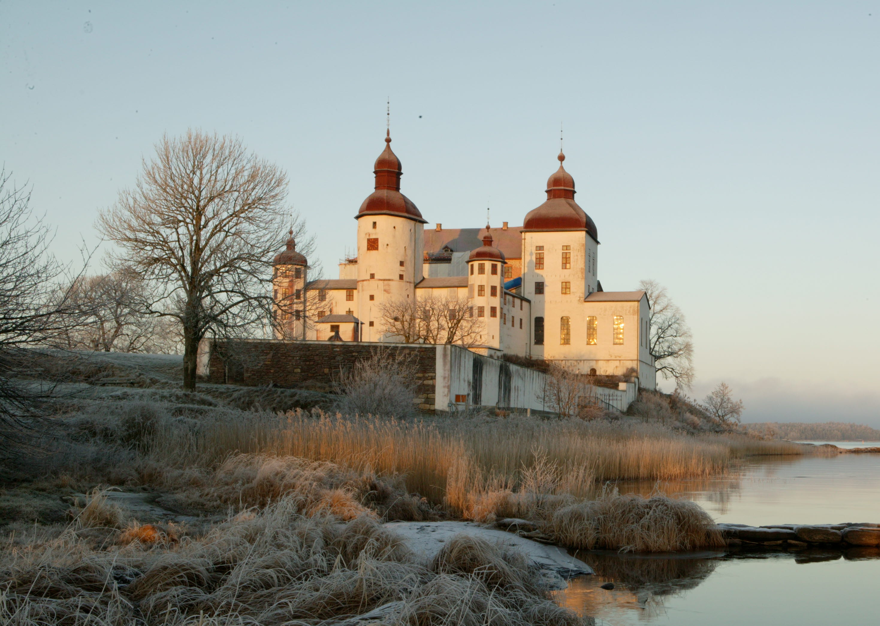 Ett vitt slott vid en sjö i ett vinterlandskap
