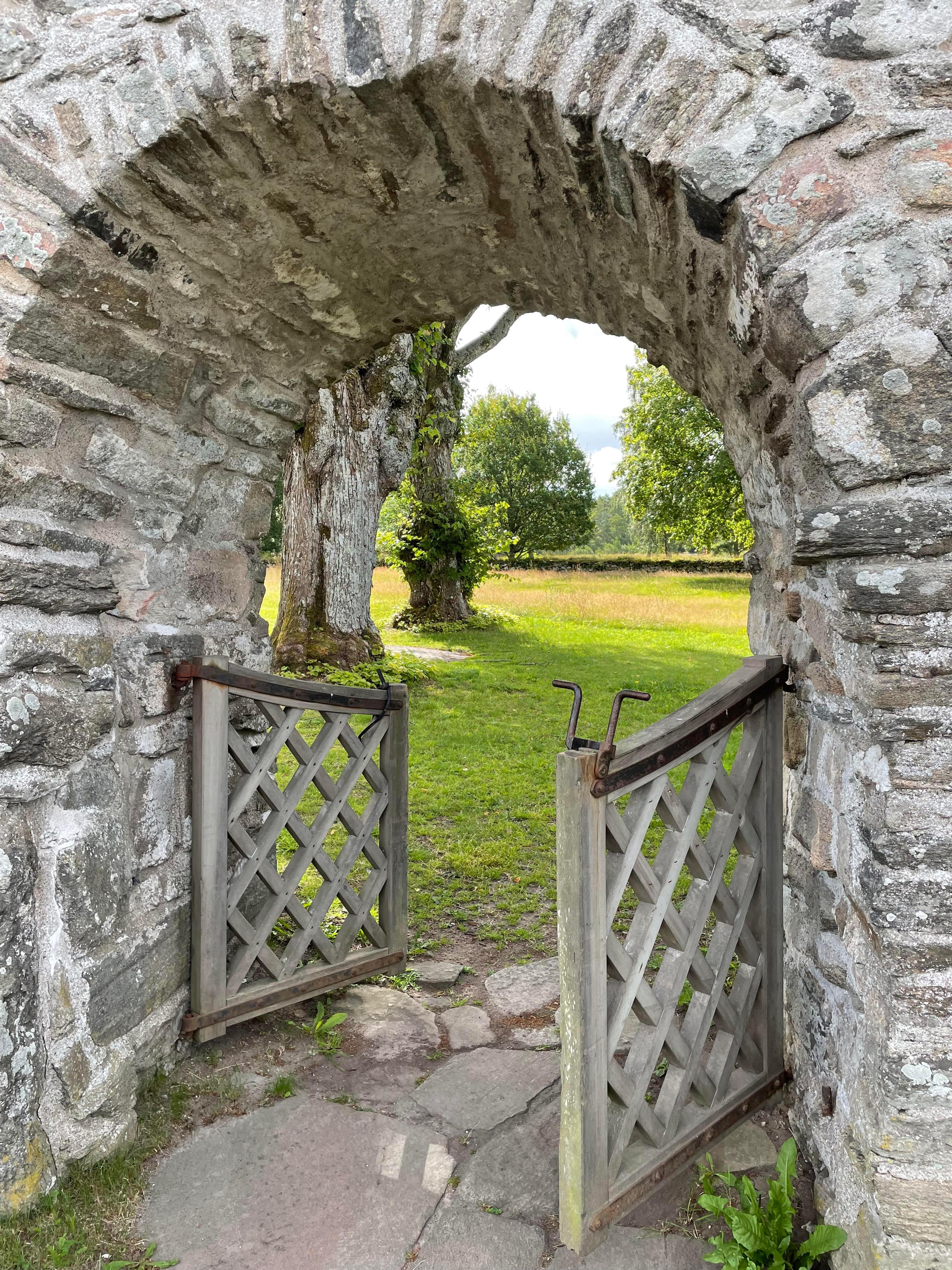 forntidsvandring, stenmur med valvad ingång till gammal kyrka
