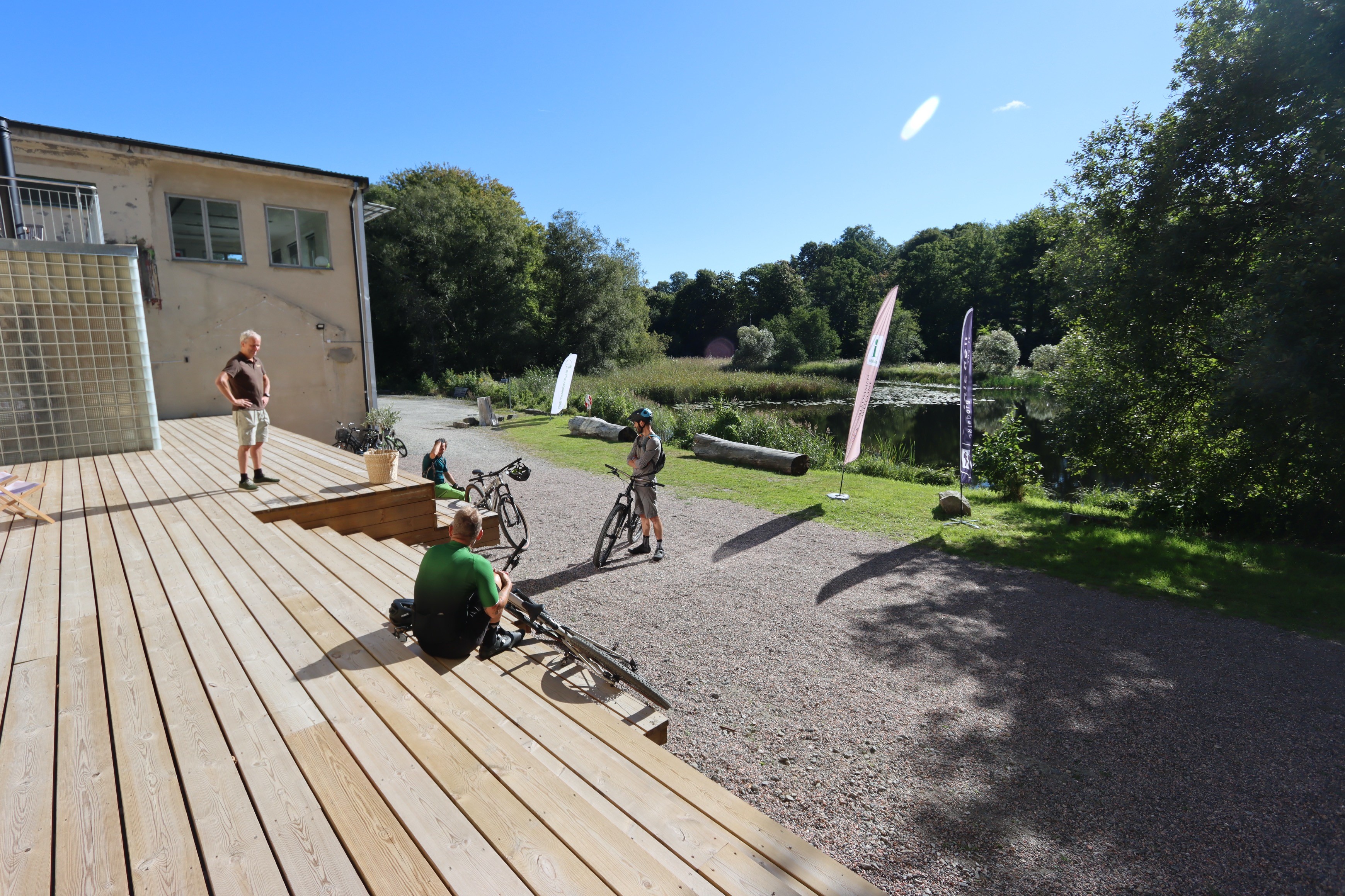 personer på altan med cykel och solig himmel