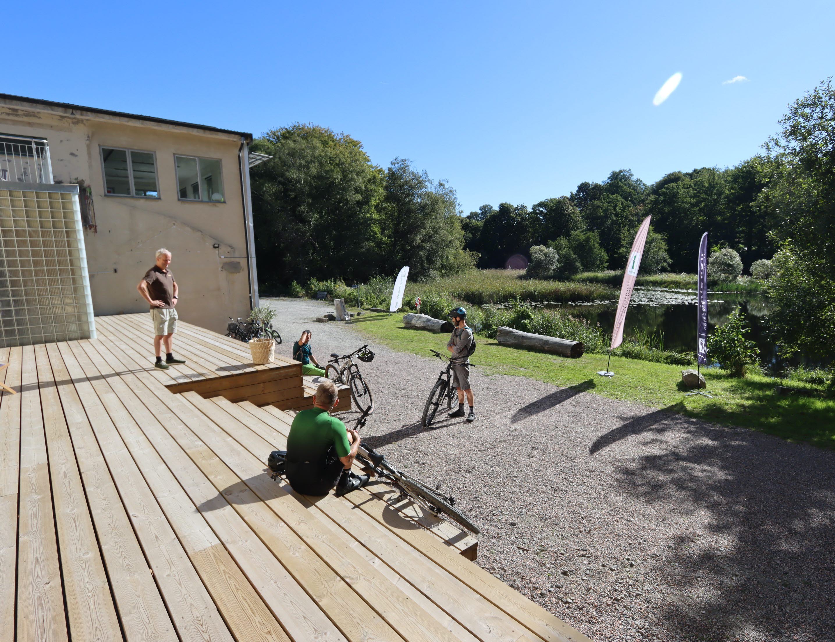 personer på altan med cykel och solig himmel