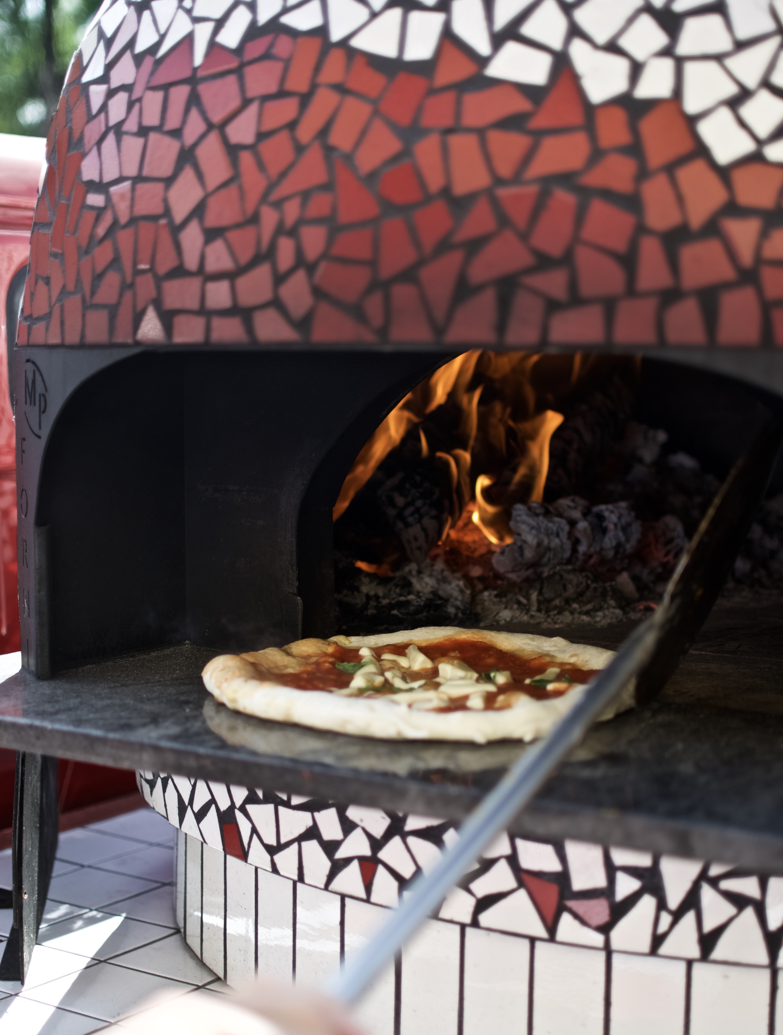 Röd italiensk pizzaugn med gräddad pizza i, un limone