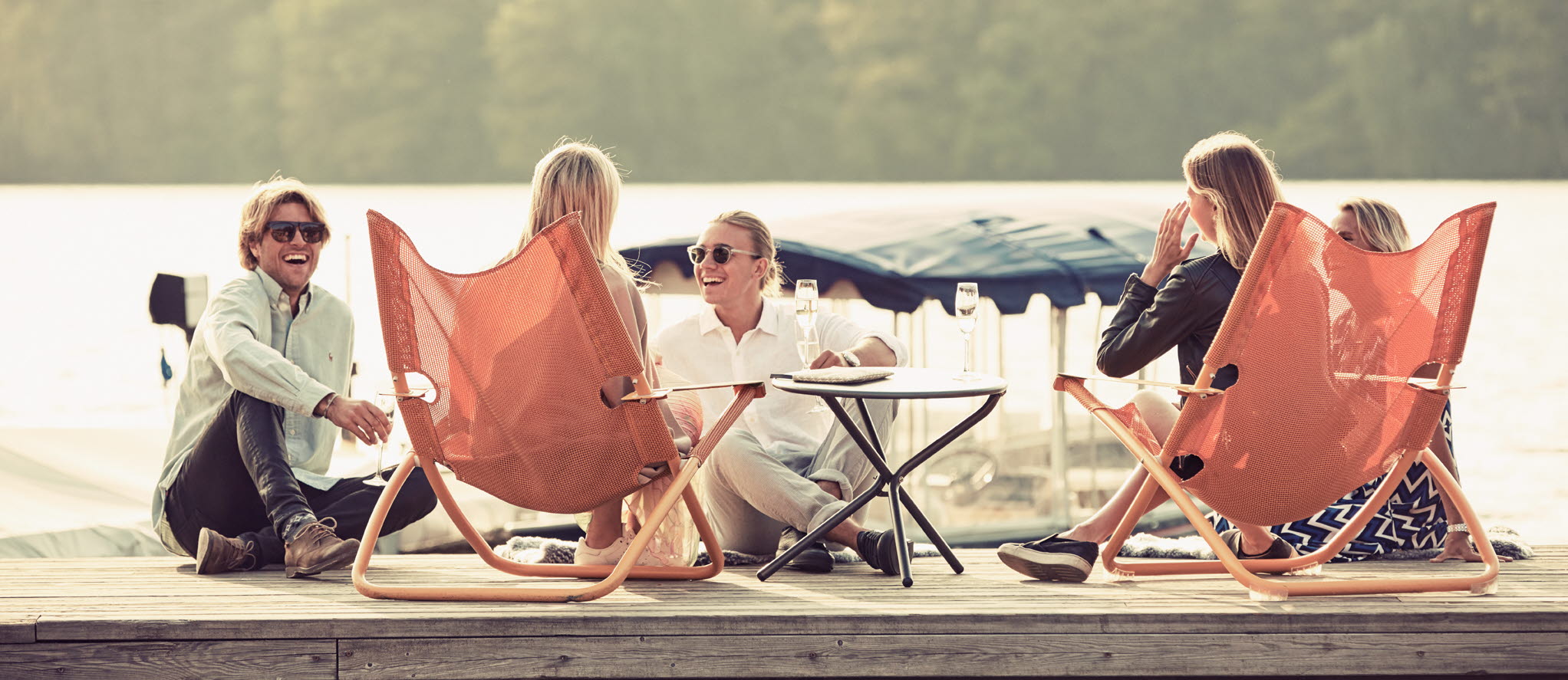 människor som sitter på solstolar på brygga