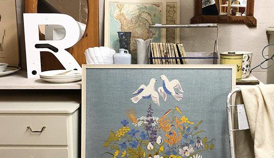 Bild på en mängd retroprylar till försäljning - allt ifrån tavla, byrå, spelgel och lampa till stol och kobratetelfon.