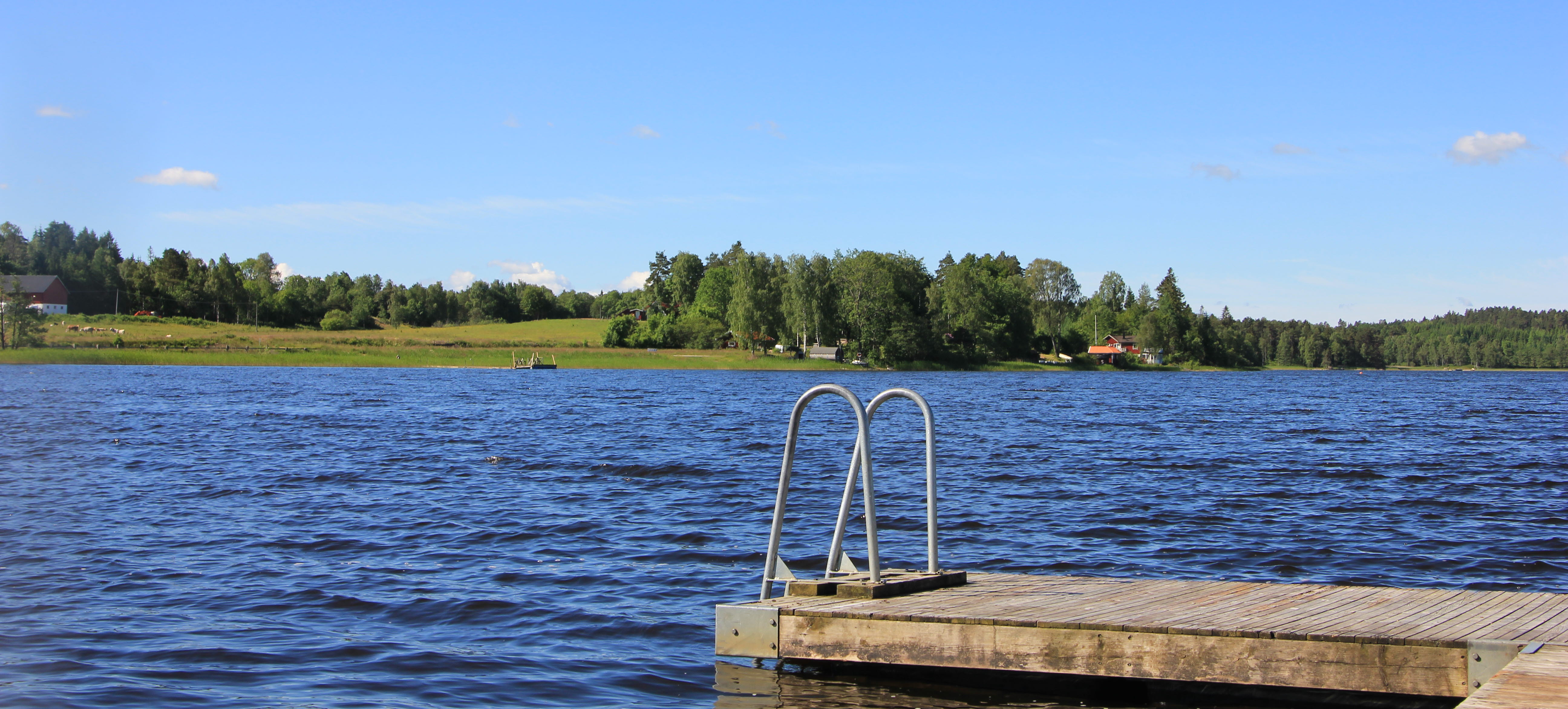 Badstege från en brygga vid en sjö en solig dag.