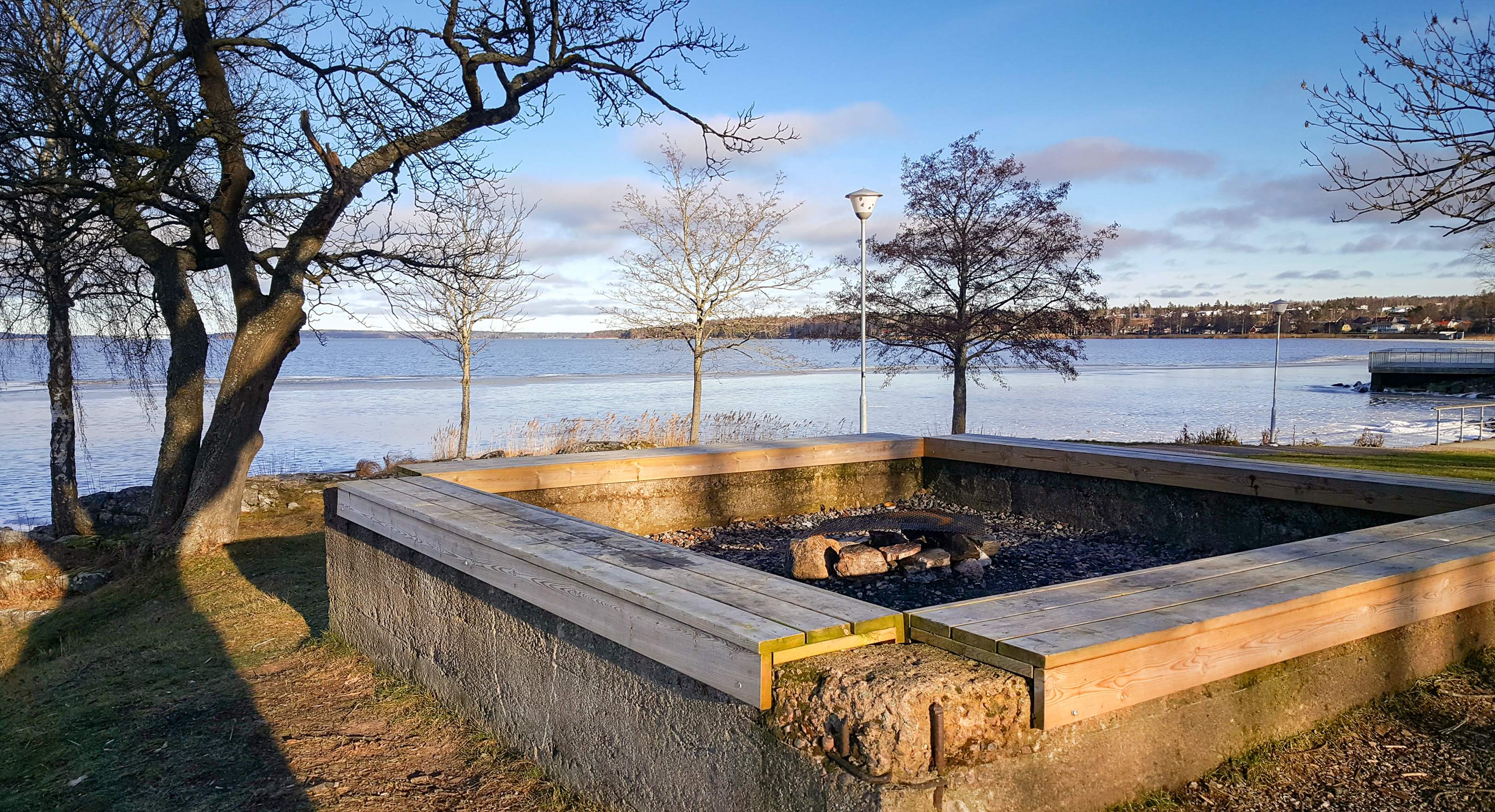 Grillplats med sittbänkar vid vattnet.