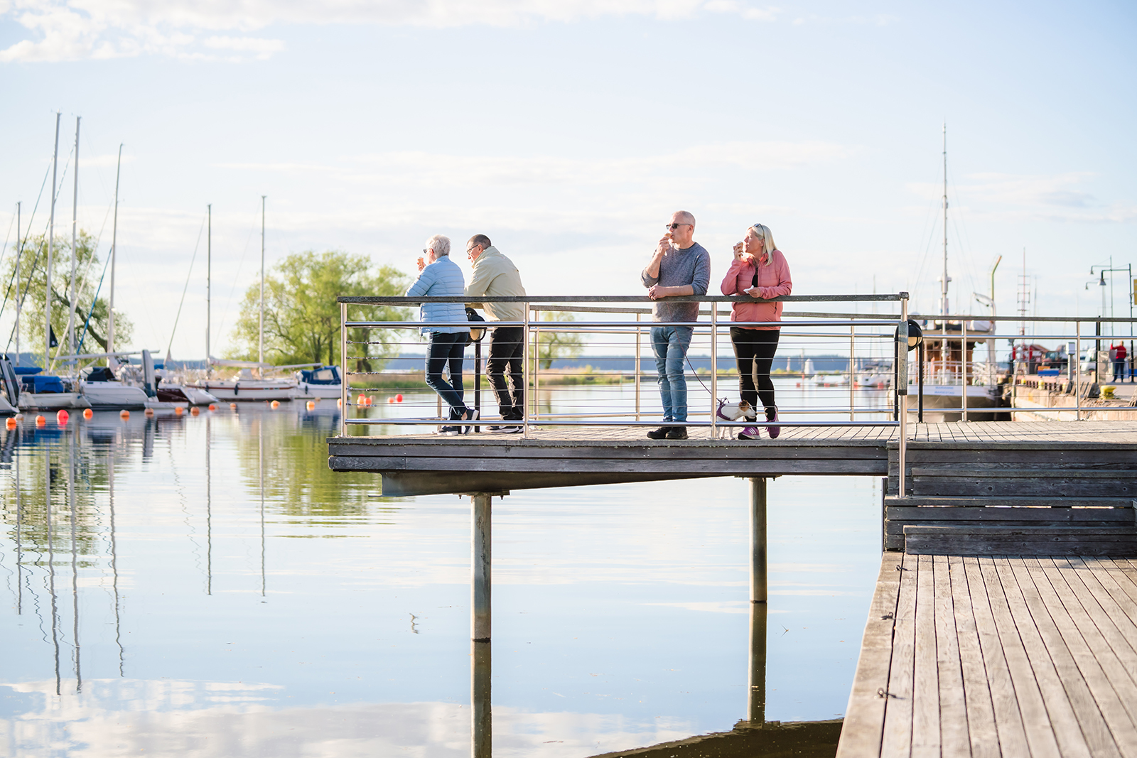 Fyra personer äter varsin glass i Mariestads gästhamn.