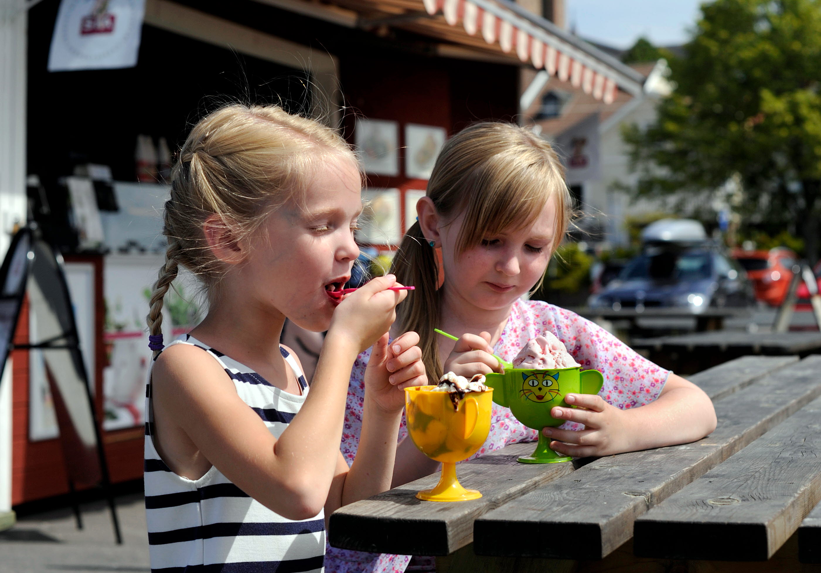 Barn äter glass vid bodarna i Mariestads gästhamn. En av de röda bodarna syns i bakgrunden.