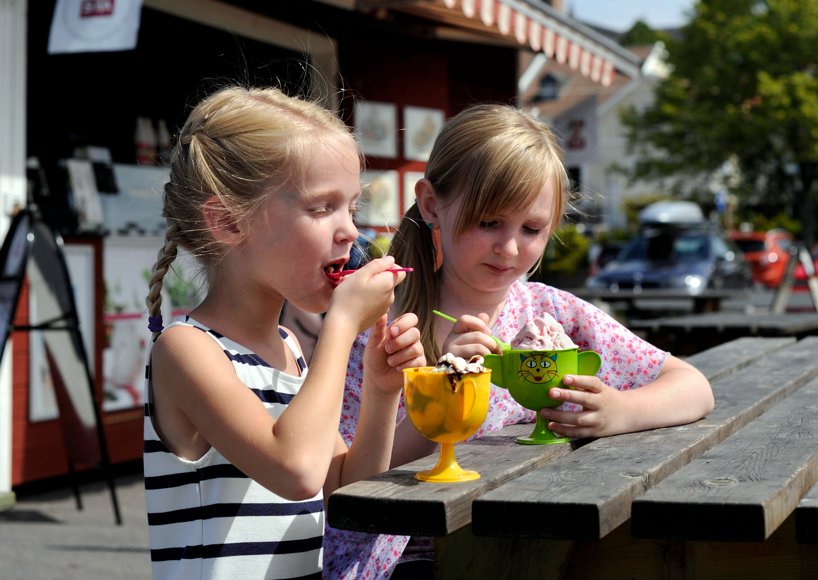 Barn äter glass vid bodarna i Mariestads gästhamn. En av de röda bodarna syns i bakgrunden.