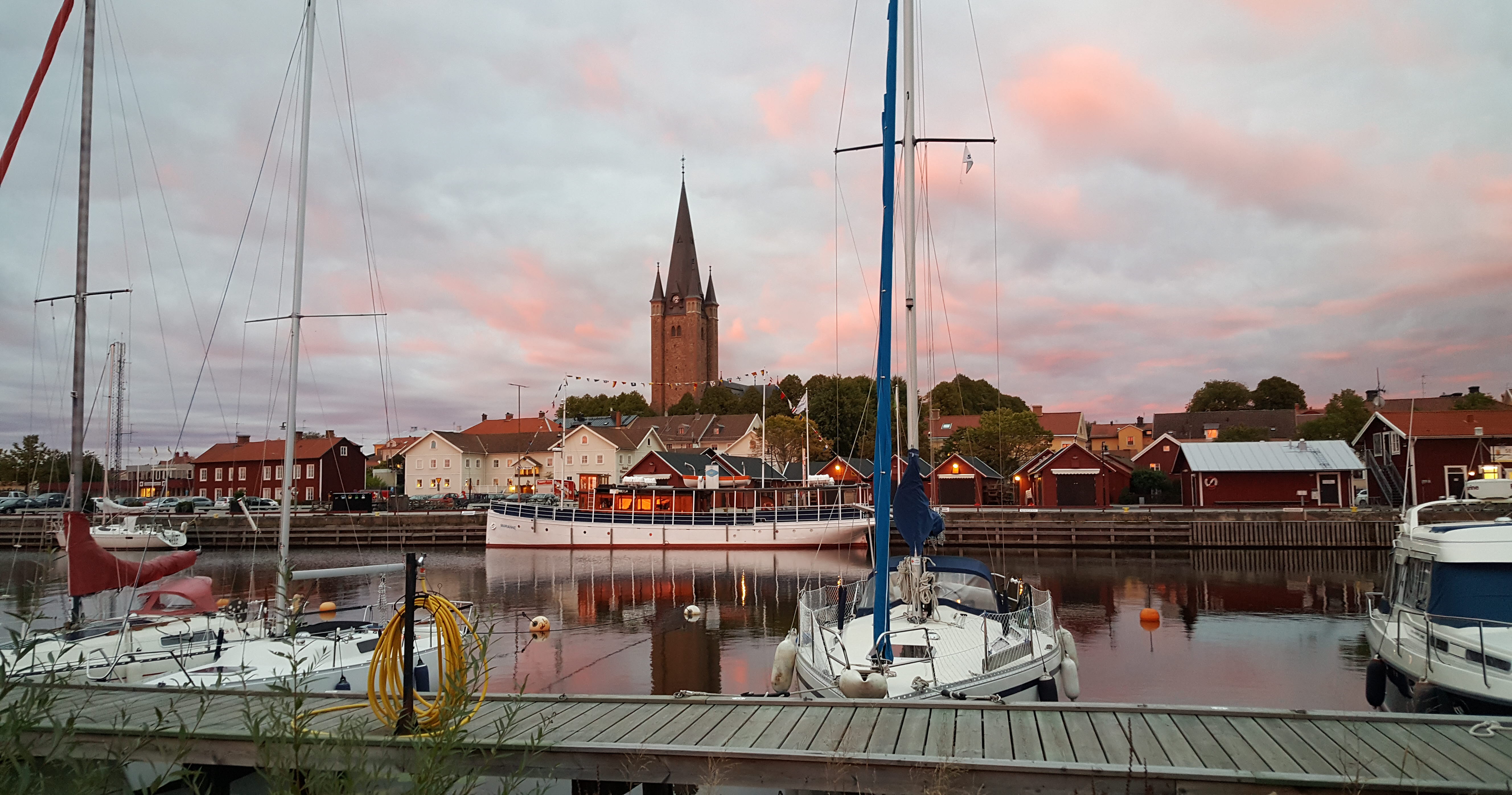 Sunset with a few boats in the harbor in Mariestad, the Old Town and the cathedral in the background.