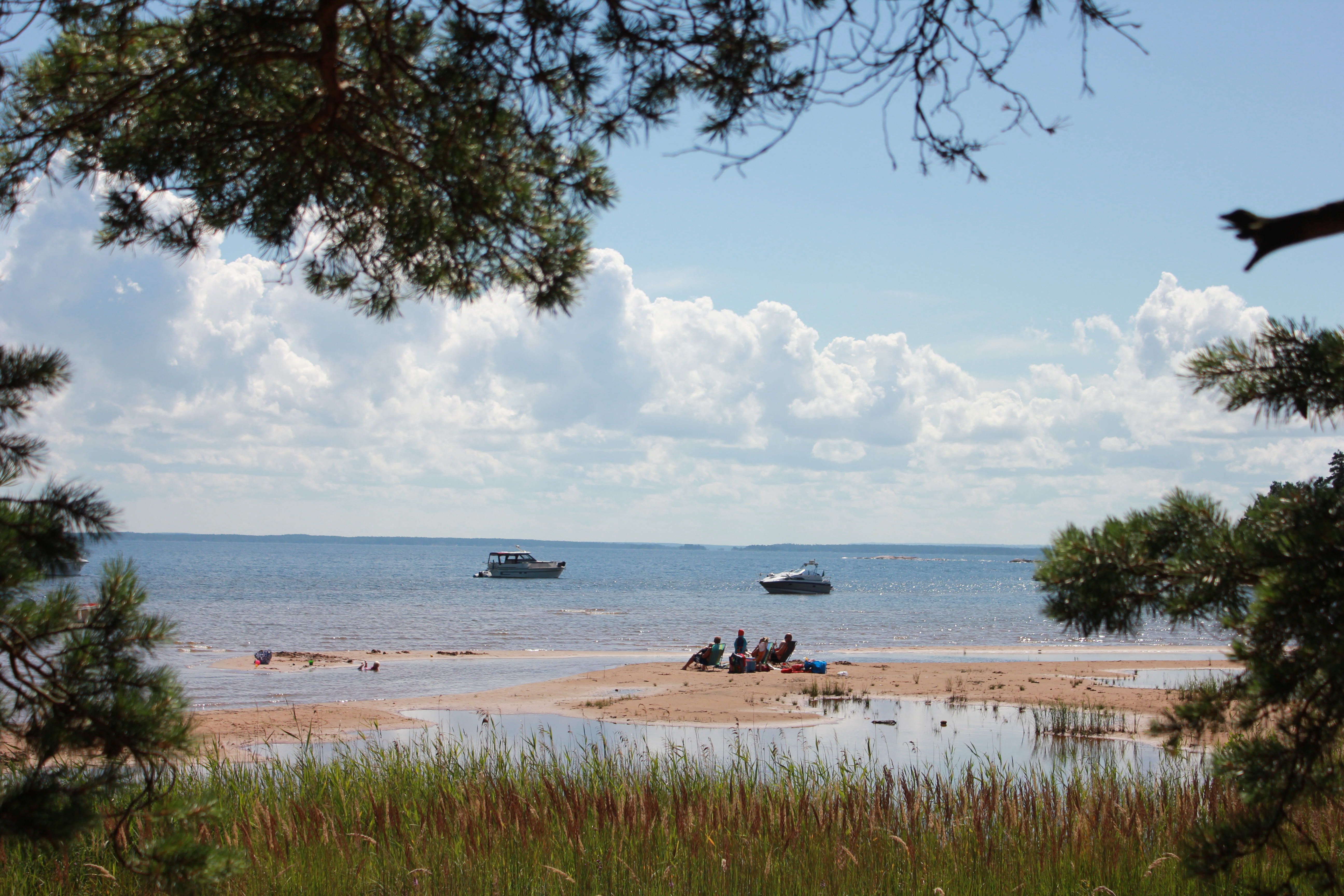 Människor som solar och badar på sanddynerna vid Hovden på Brömmö i Vänerns skärgård. 