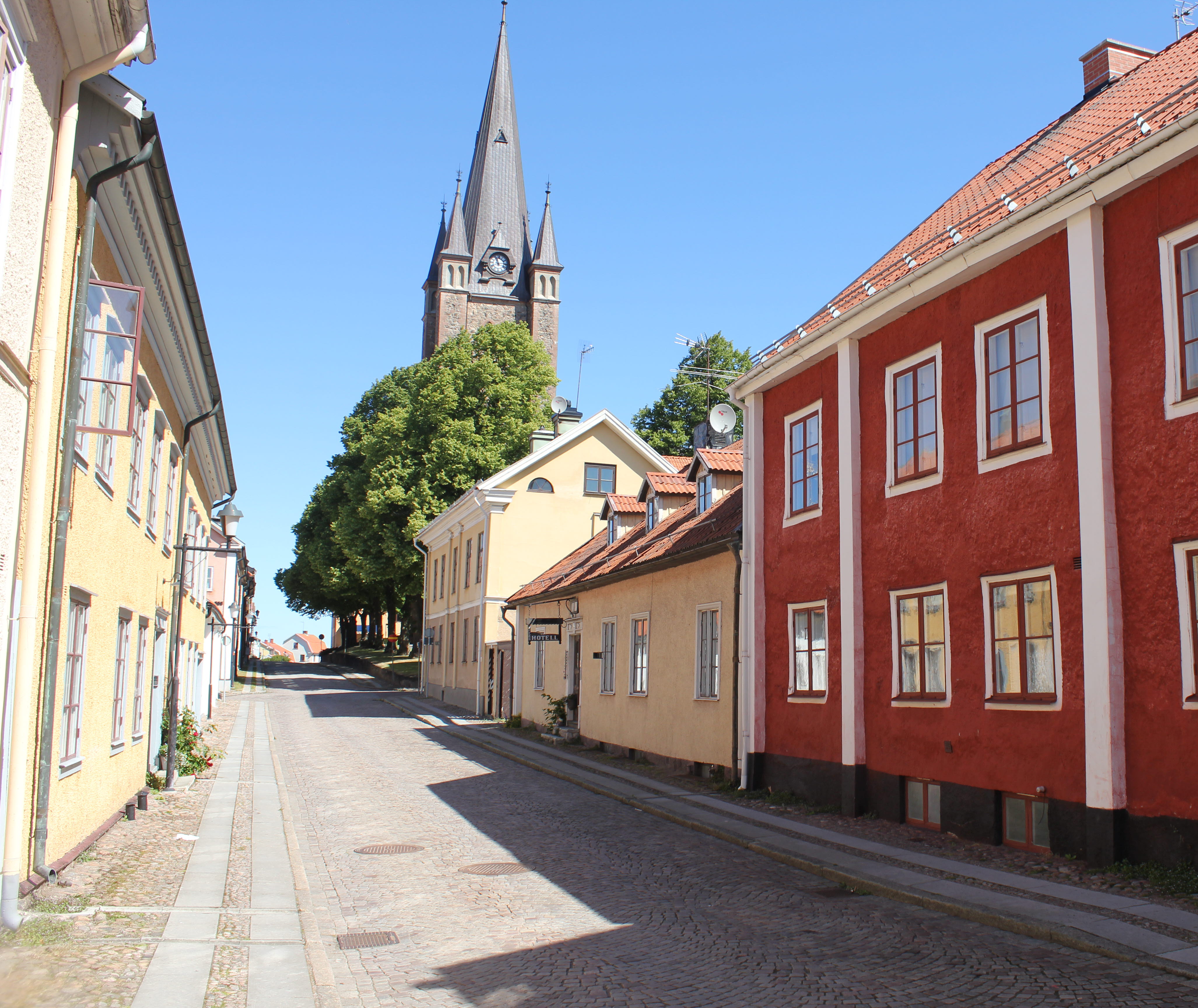 Old town in Mariestad with the cathedral in the background. The sun is shining and the sky is blue. 