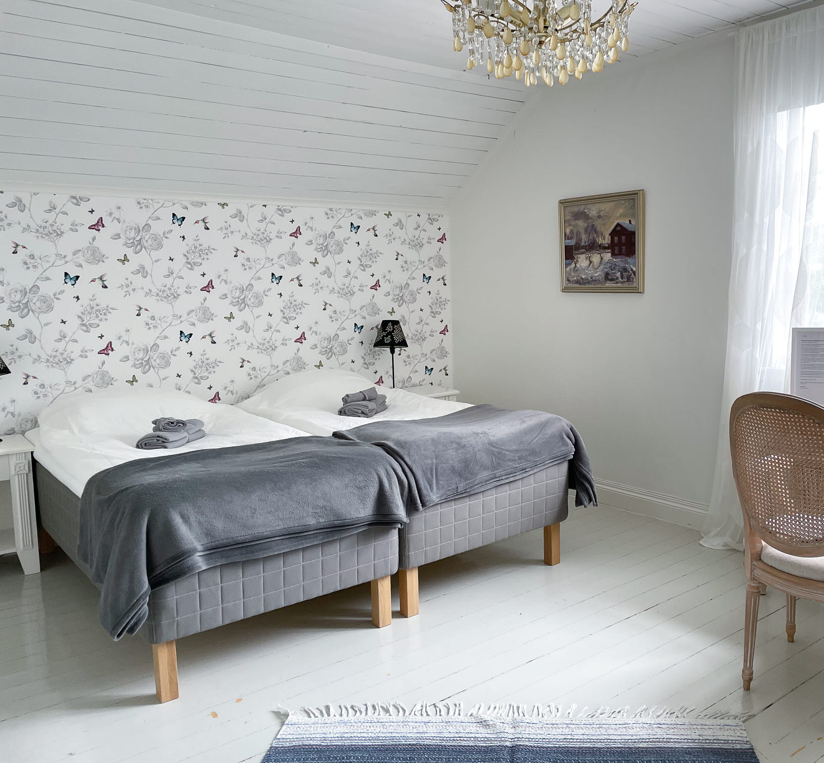 Del av familjerum på Lyrsta R B&B, dubbelsäng och skrivbord med stol vid fönstret. 