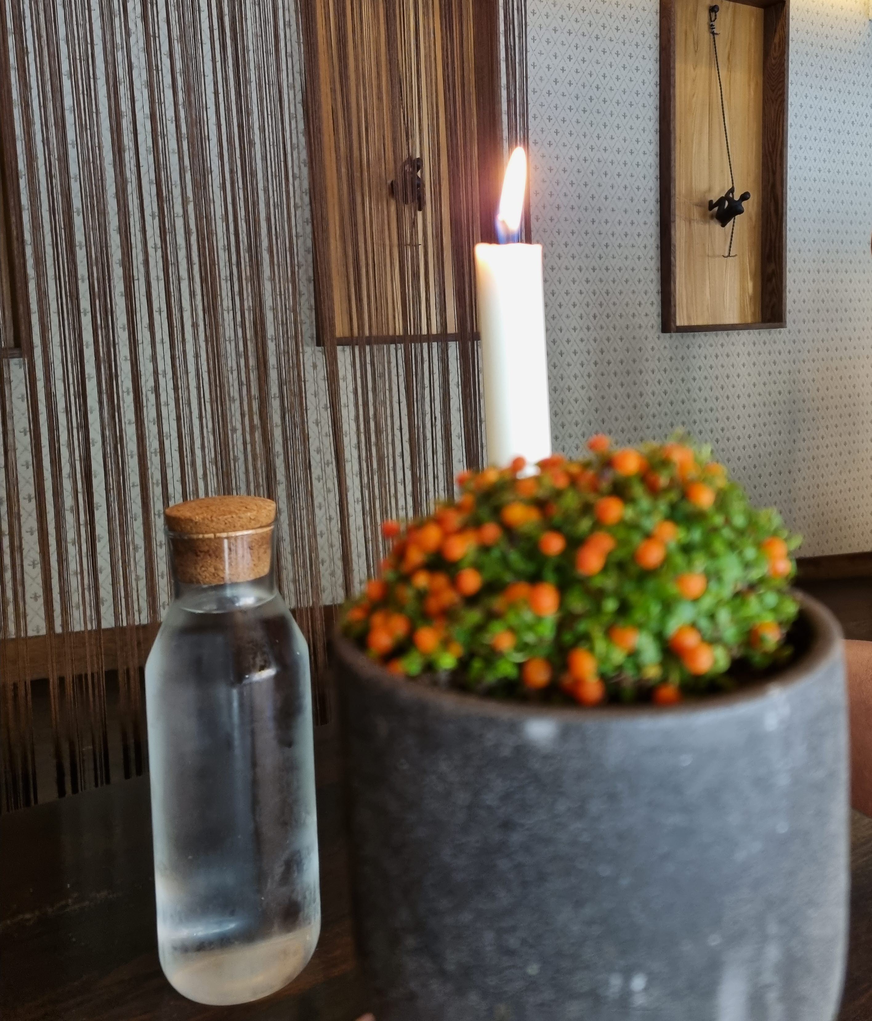 Blomma, vattenflaska och ett stearinljus.