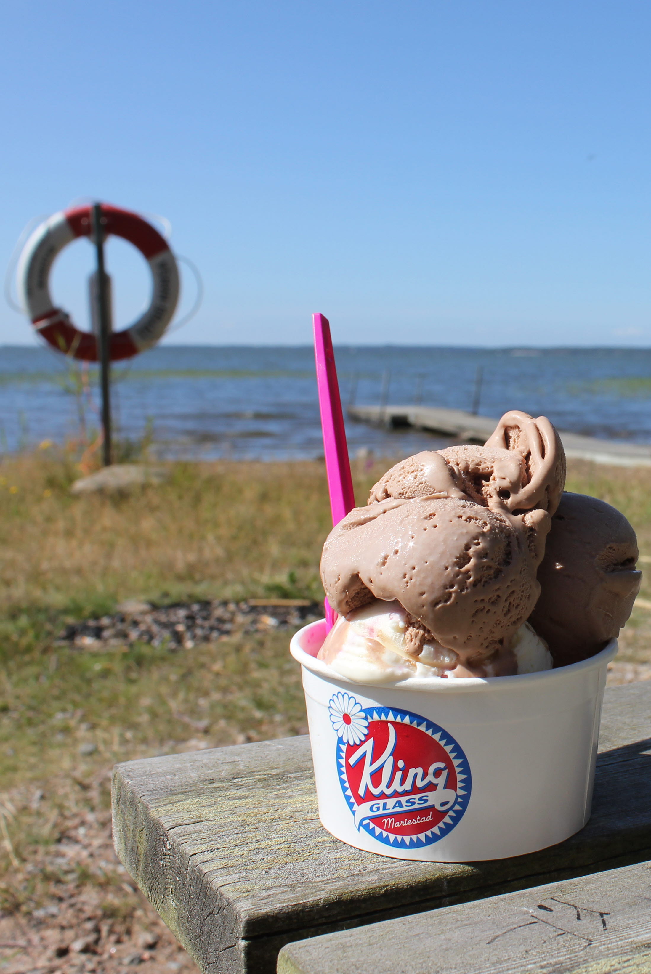 Kling glass i bägare som står på en bänk vid Bäcken. Utsikt över Vänern.