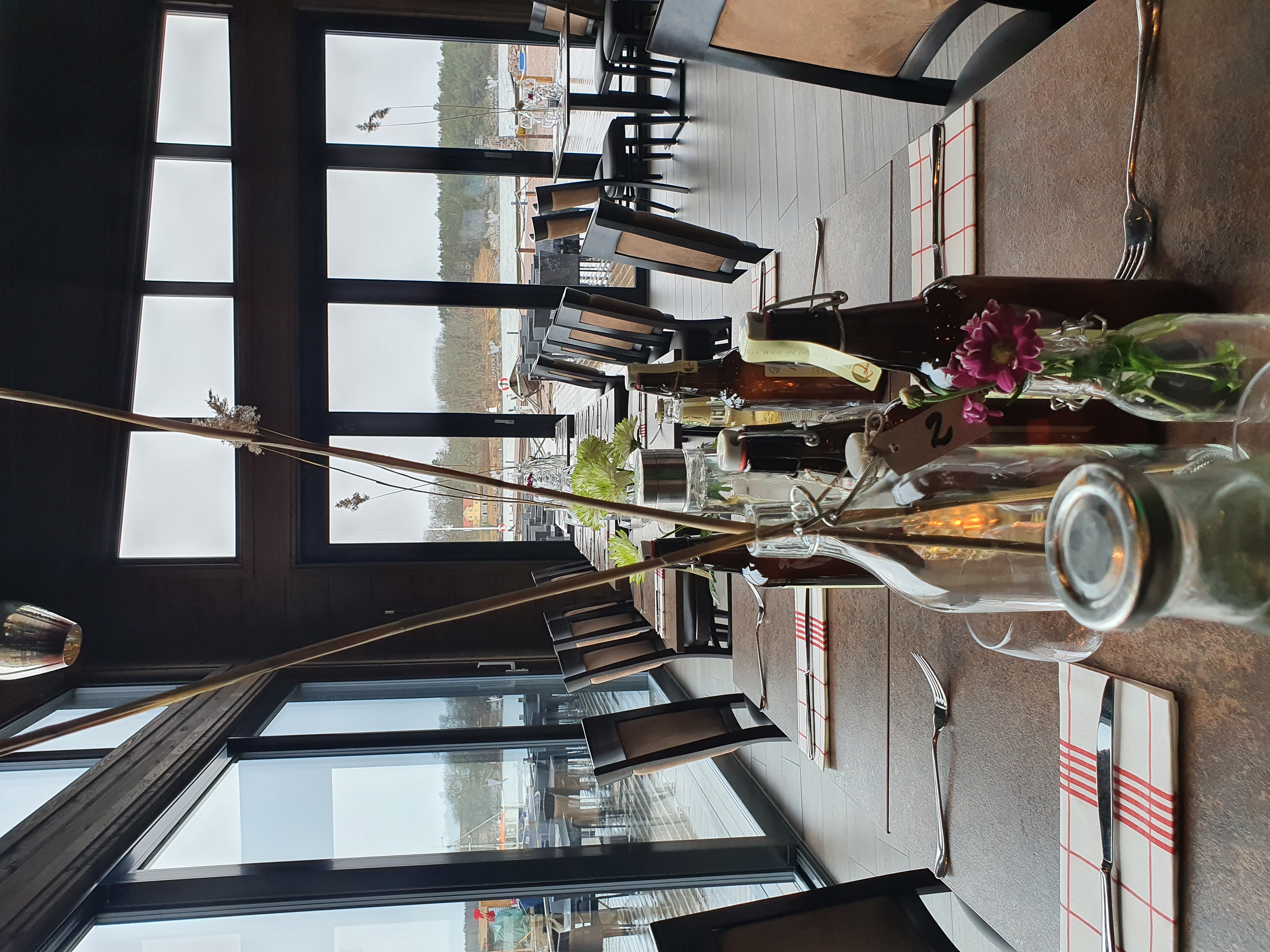 Dukat bord vid glaspartier med utsikt över sjö.