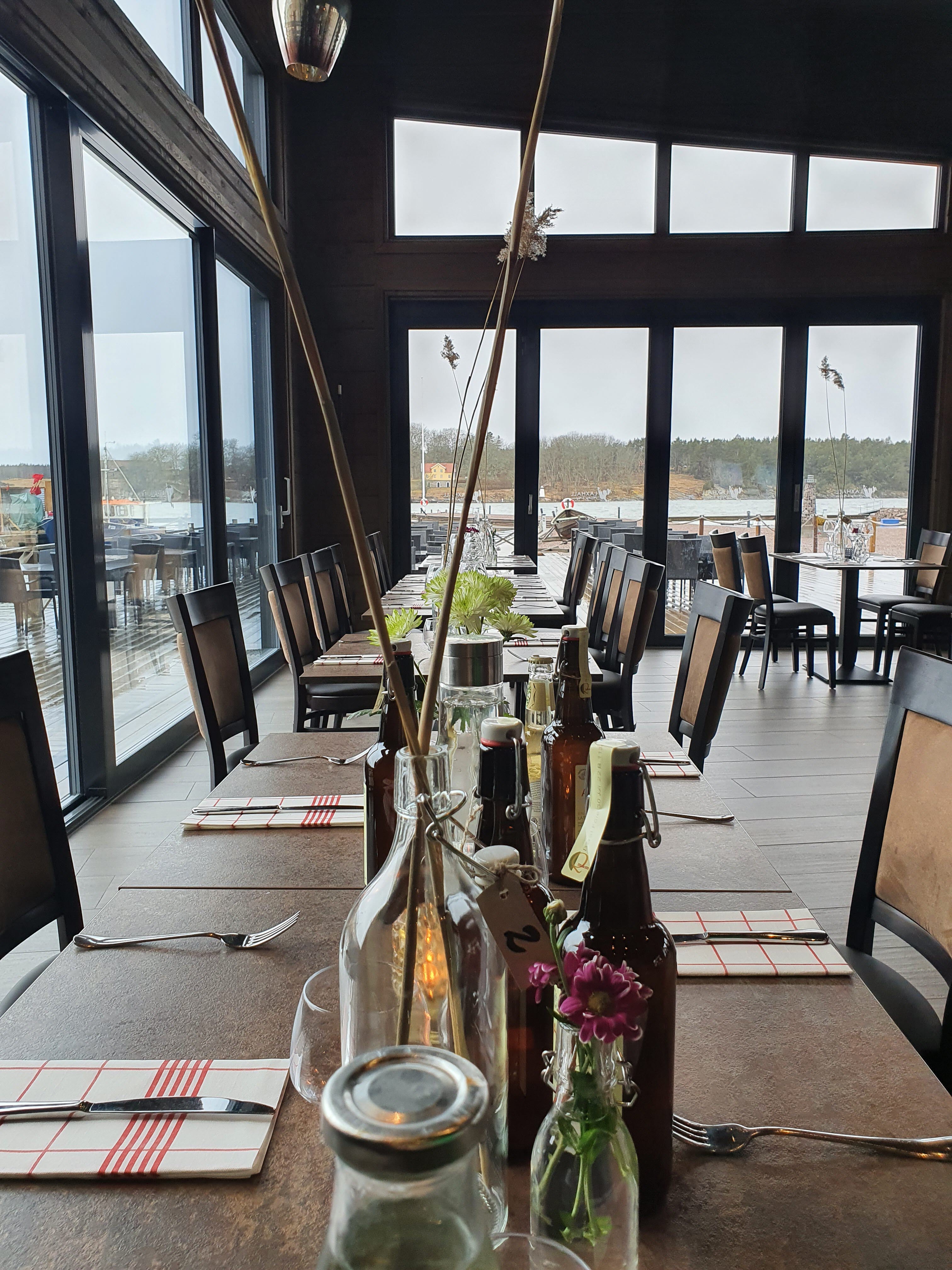 Dukat bord vid glaspartier med utsikt över sjö.