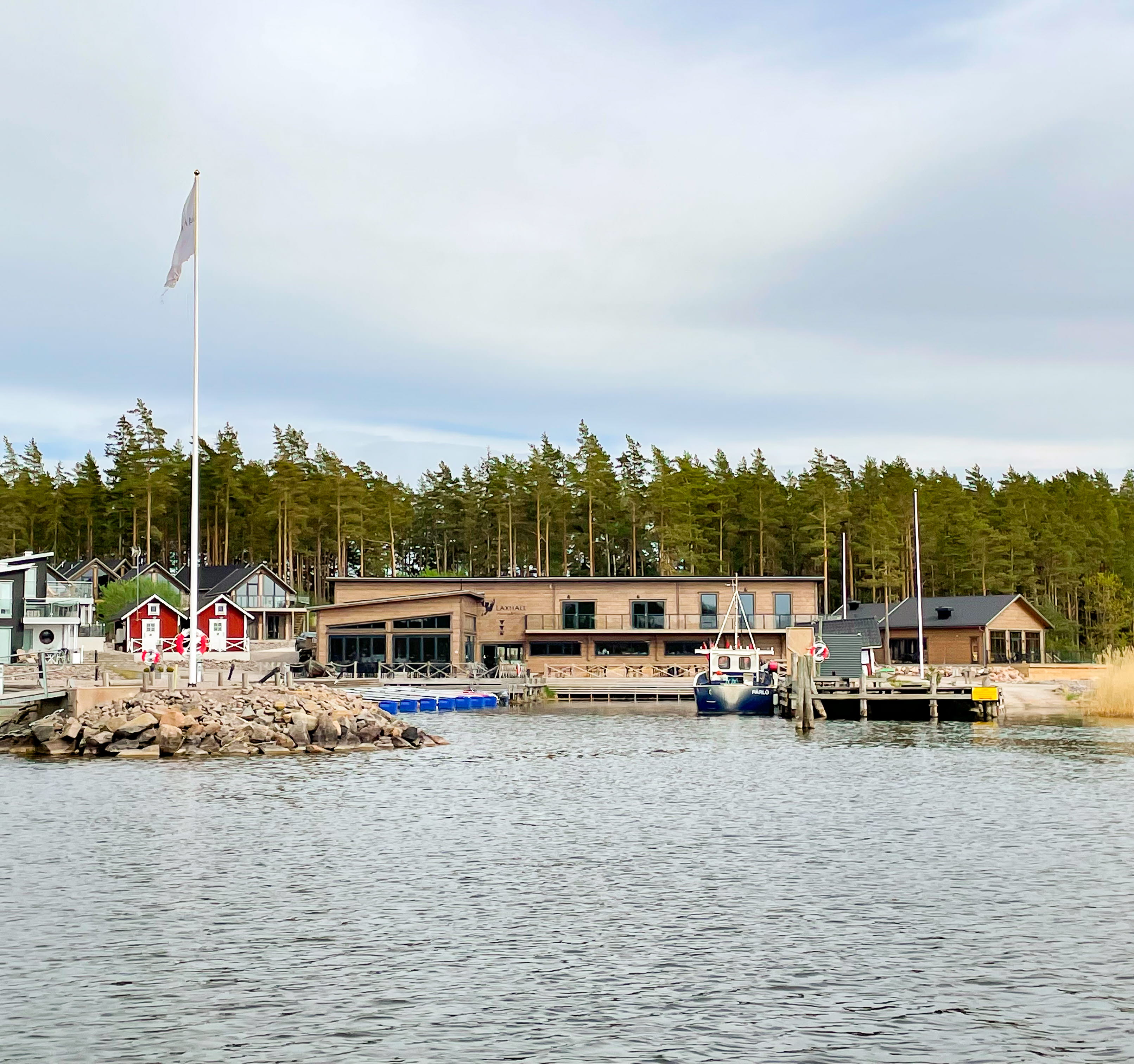 Vatten, byggnader, gästhamn, himmel och träd.