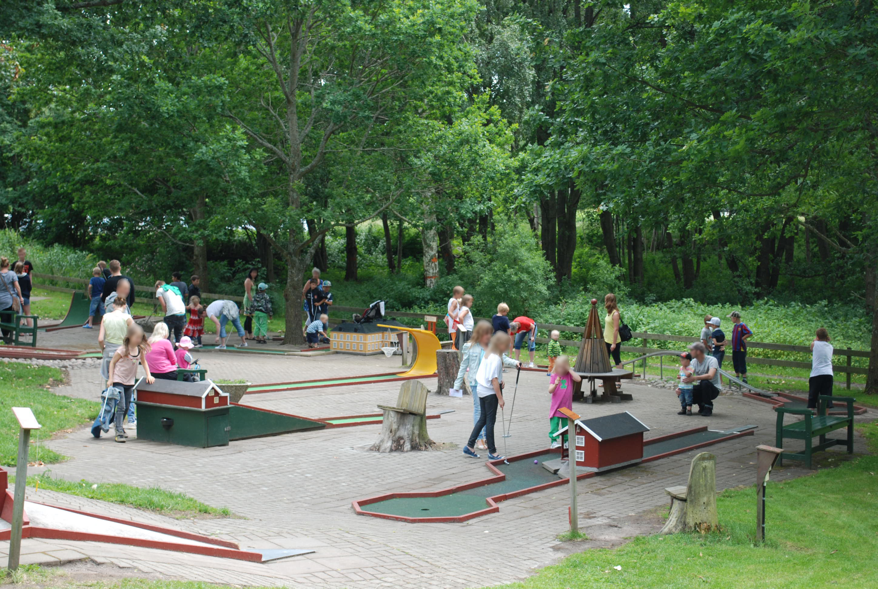 Besökare spelar minigolf på Sommargården Bäcken i Mariestad.