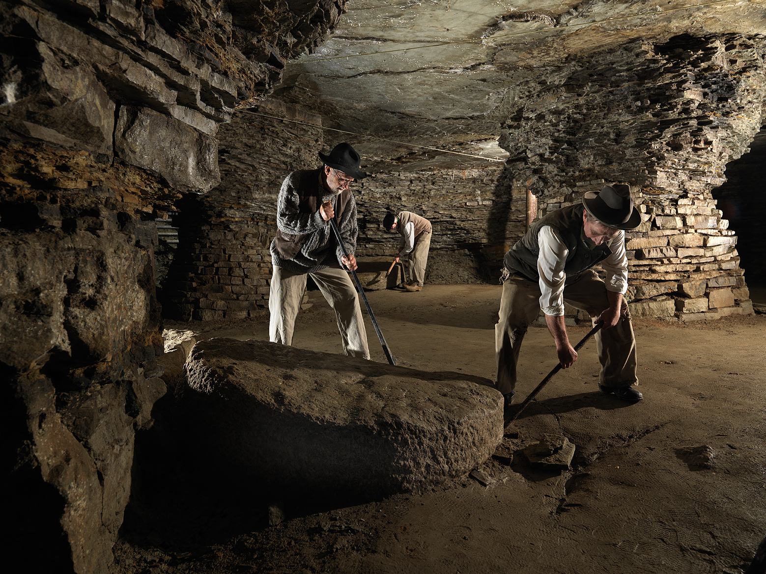 Tre äldre män som står och gräver i  Qvarstensgruvan. 