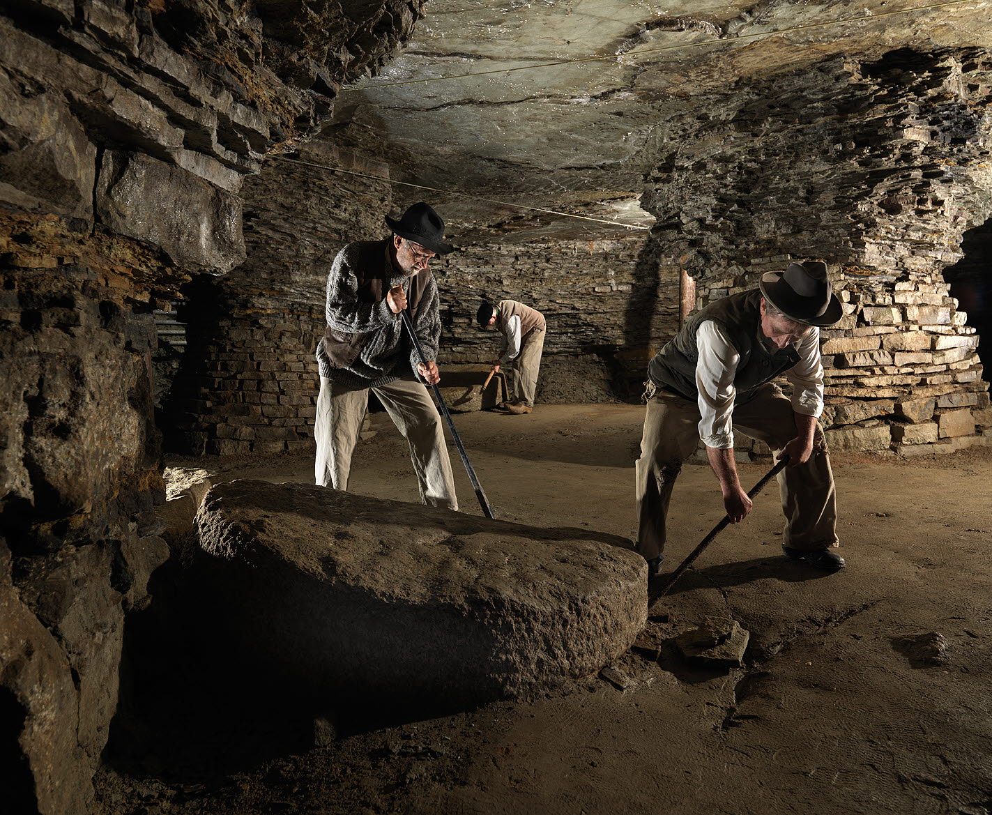 Tre äldre män som står och gräver i  Qvarstensgruvan. 