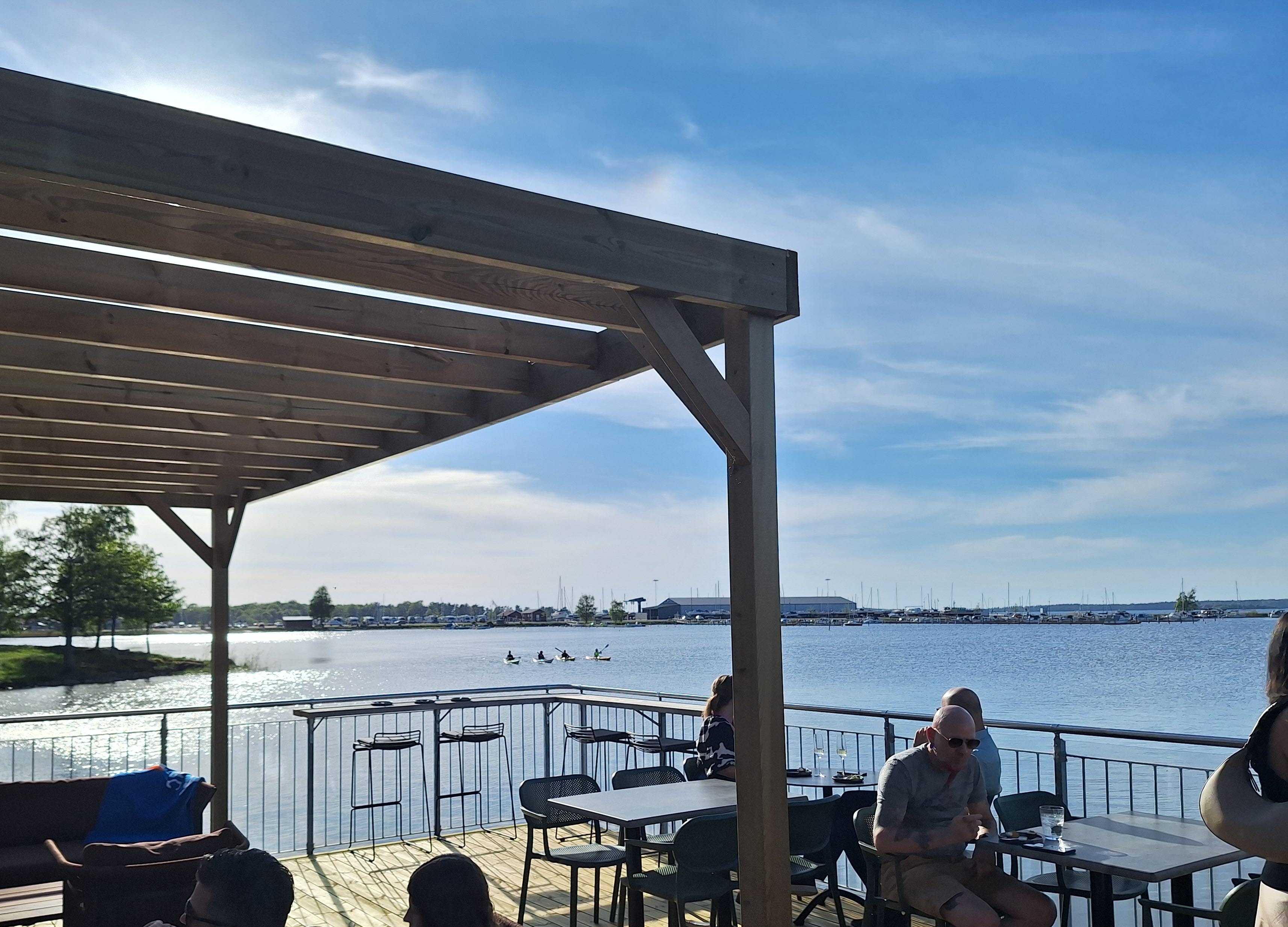 Uteservering med människor vid bord på en brygga i Vänern.