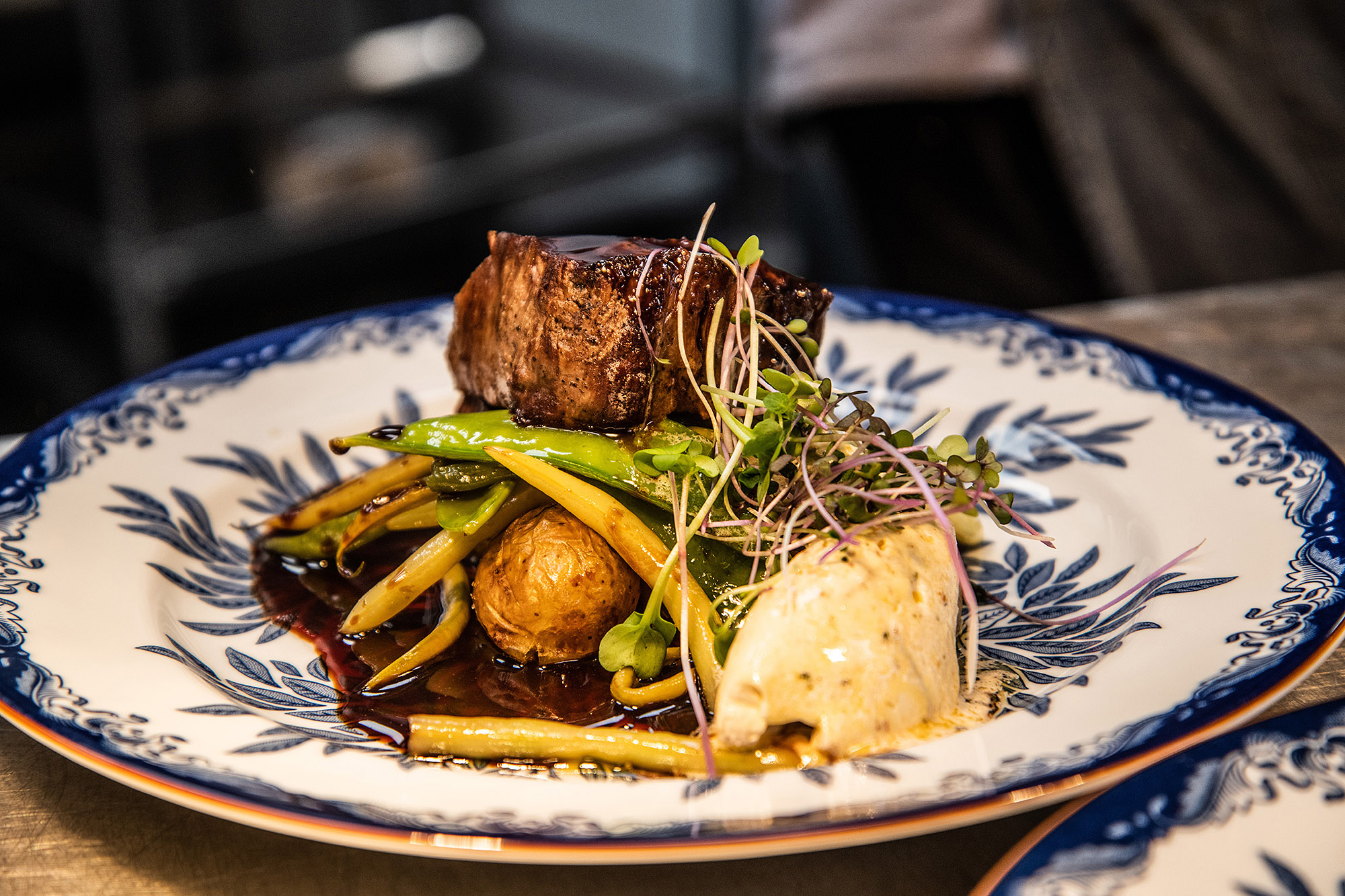 Tallrik med kötträtt och grönsaker på restaurang.