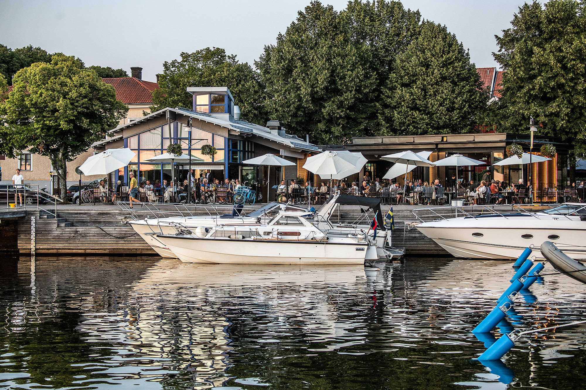 Exterior view of restaurant Sill och Dynamit from the lake side with the guest harbor and boats in the foreground.