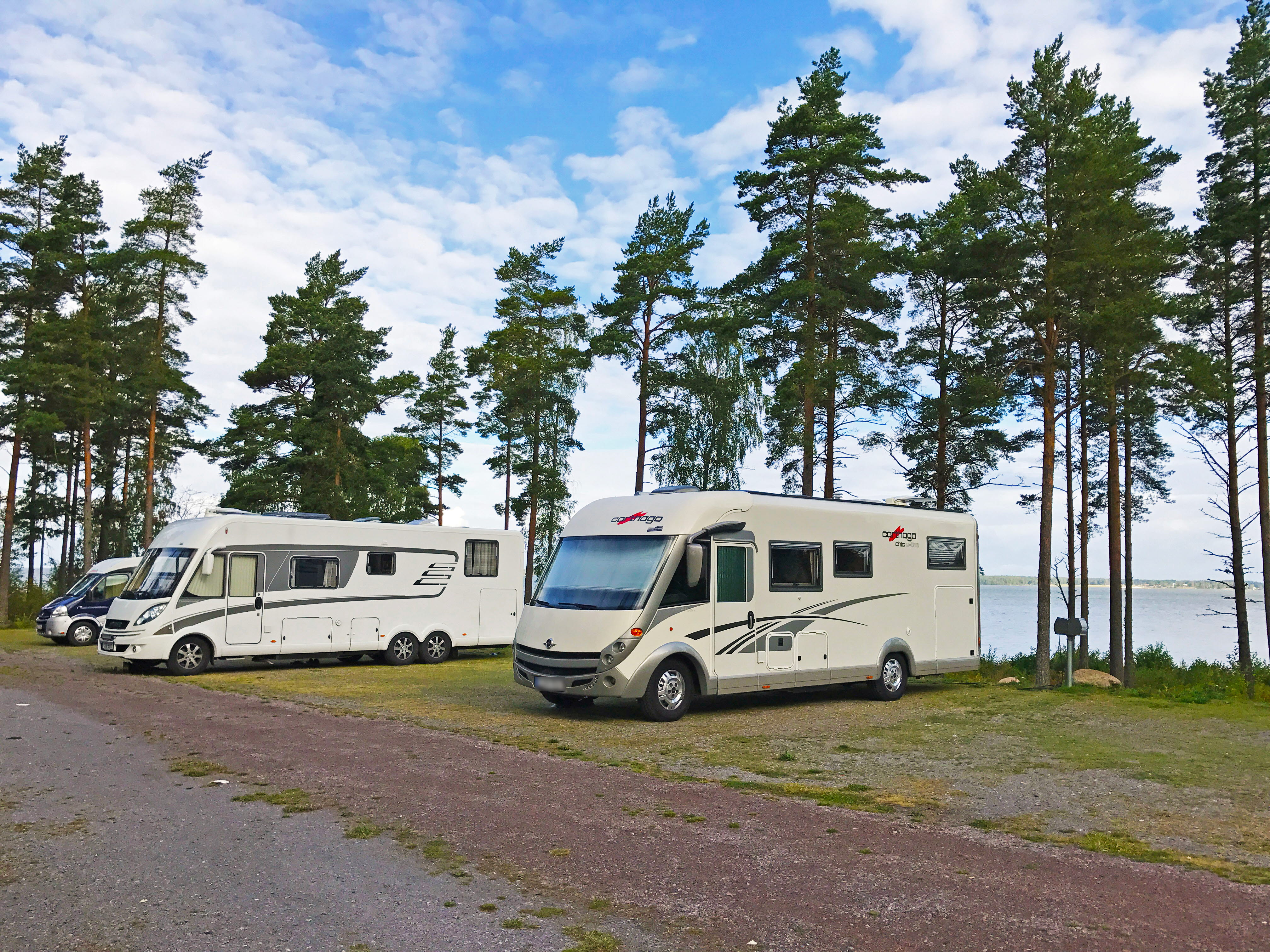 Husbilar på ställplatsen vid Mariestads golfklubb, utsikt över Vänern.
