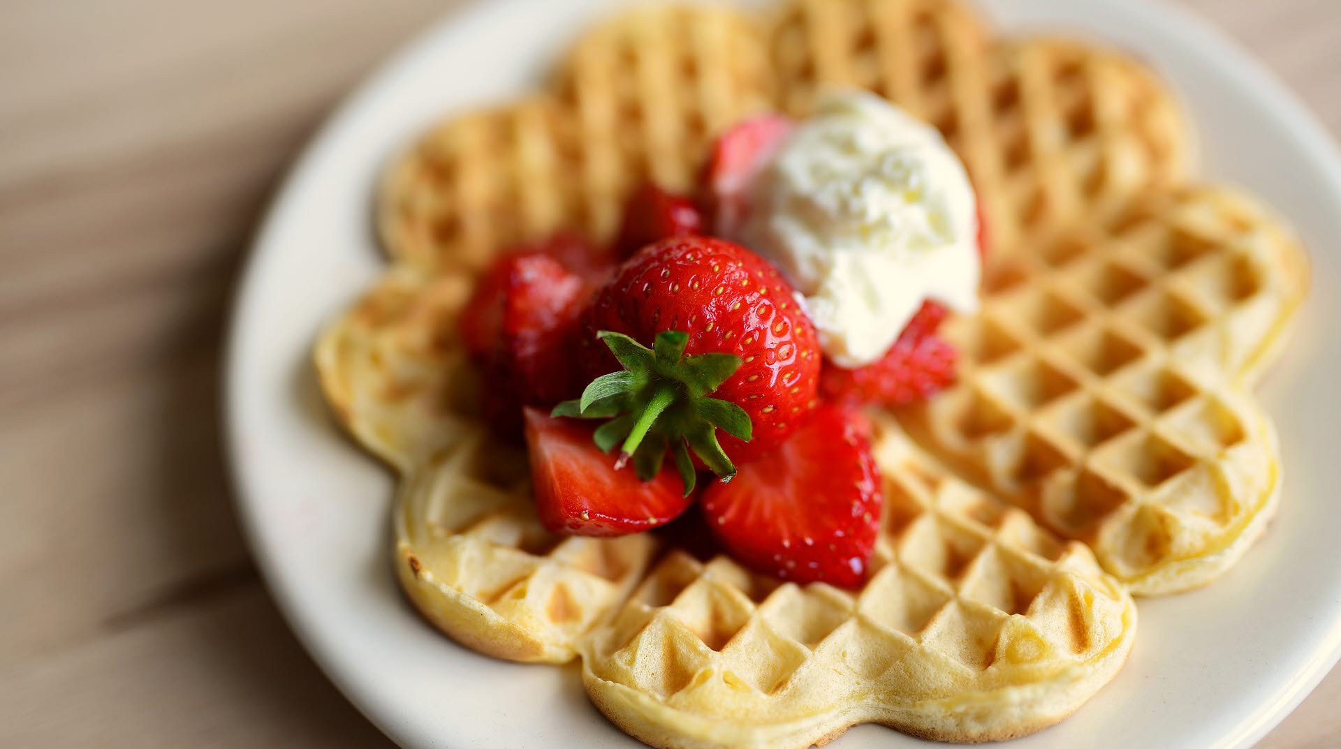 En våffla med jordgubbar och glass.