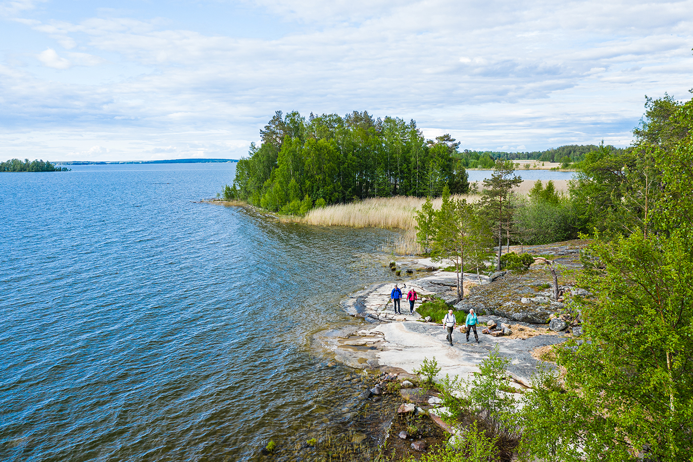 Fyra personer vandrar på klippor vid Vänern, på vandringsleden Ekudden-Sandviken i Mariestad.