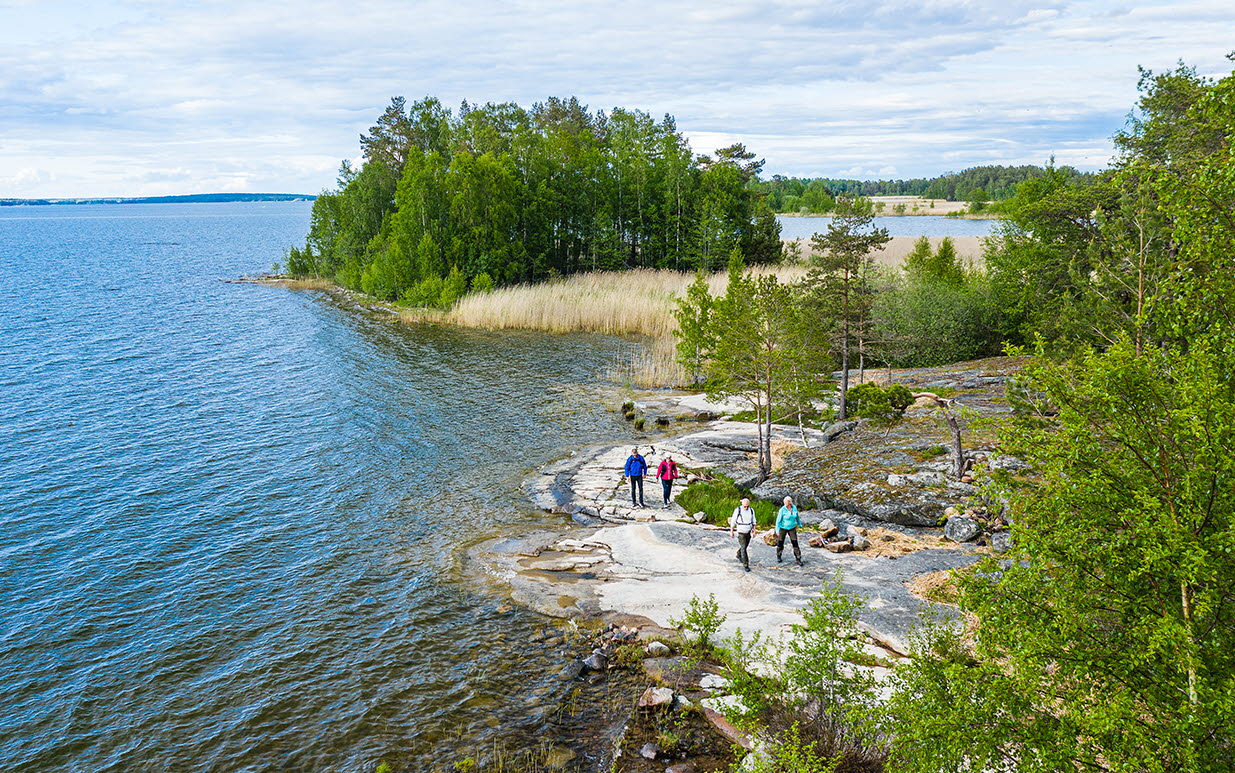 Fyra personer vandrar på klippor vid Vänern, på vandringsleden Ekudden-Sandviken i Mariestad.