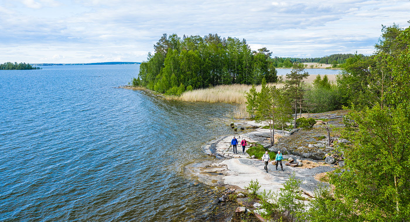 Fyra personer vandrar på klippor vid Vänern, på vandringsleden Ekudden-Sandviken i Mariestad.