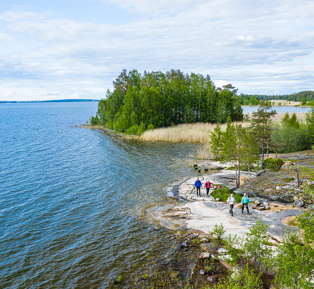 Fyra personer vandrar på klippor vid Vänern, på vandringsleden Ekudden-Sandviken i Mariestad.