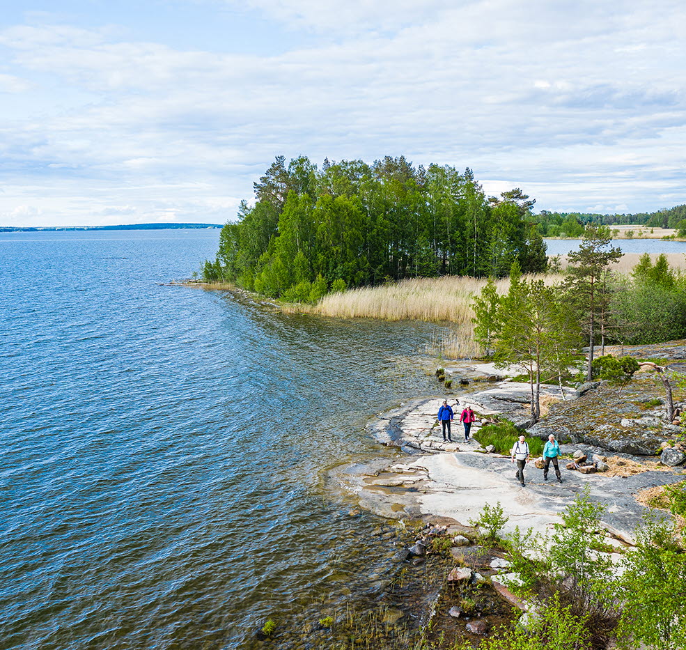 Fyra personer vandrar på klippor vid Vänern, på vandringsleden Ekudden-Sandviken i Mariestad.