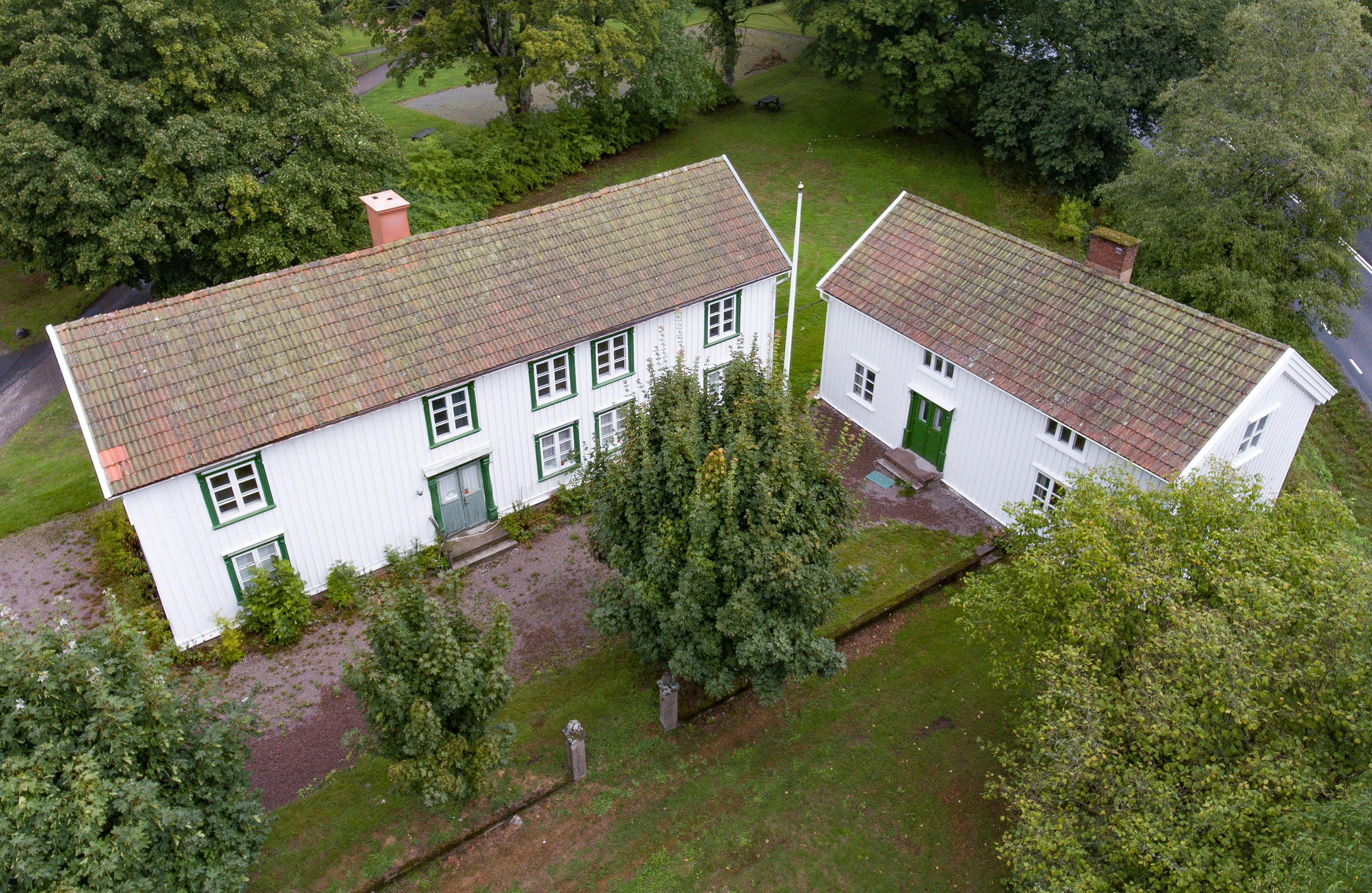 En bild på två gamla vita hus. Bilden är tagen uppifrån.