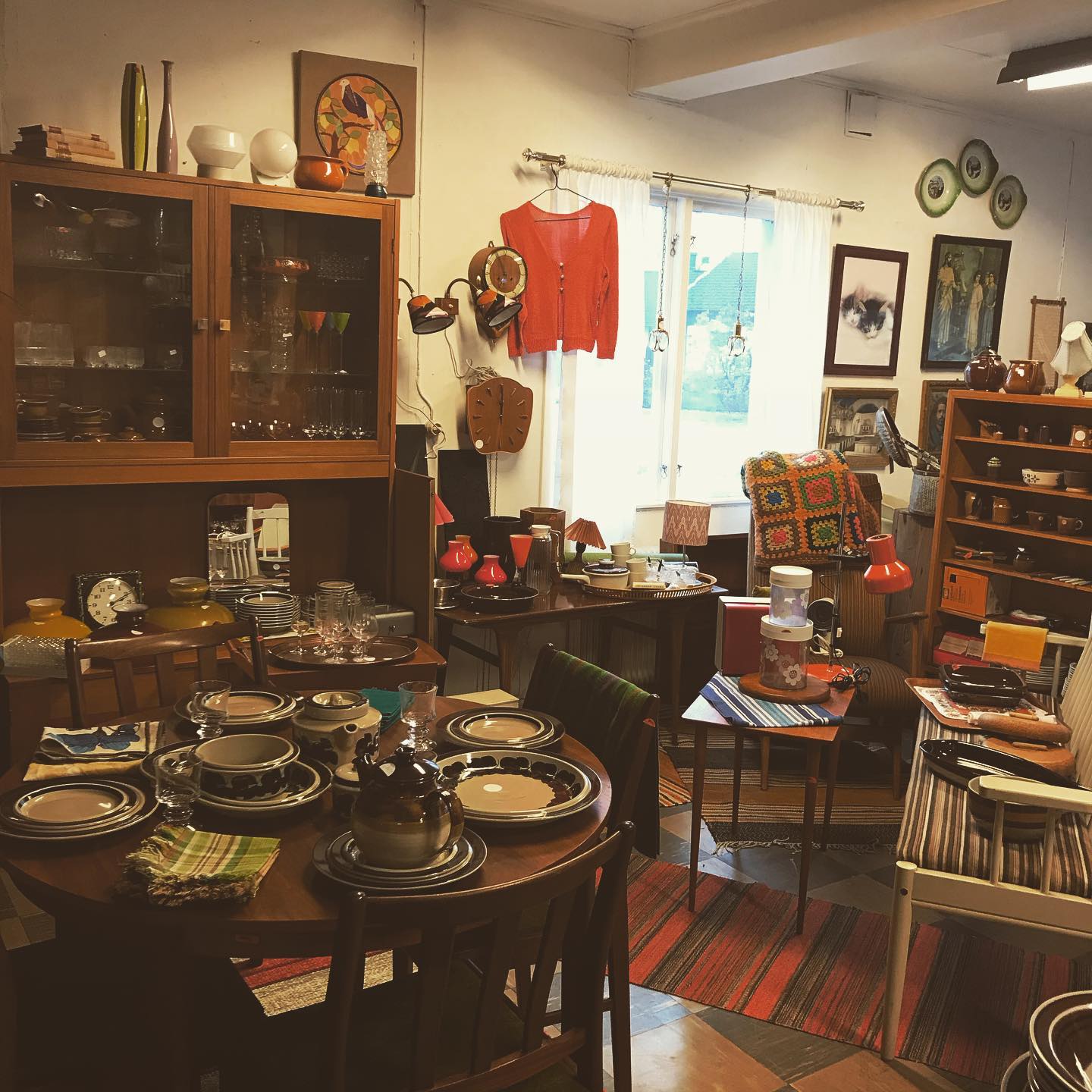 En bild inifrån en anikaffär där mängder av porsling, möbler och tavlor står huller om buller.