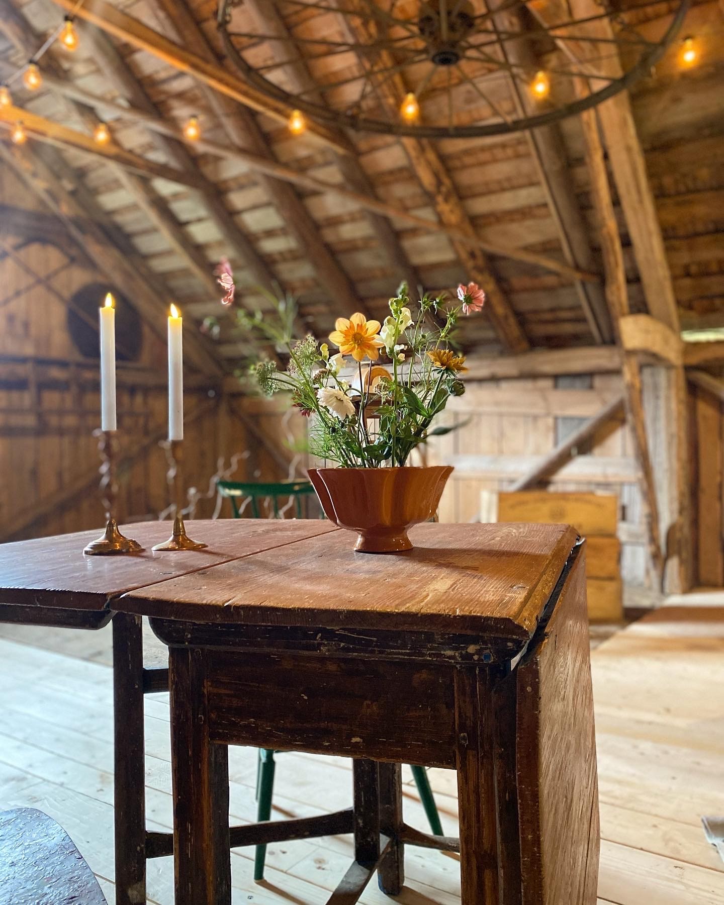 Attareds Blomster gårdsbutik, sommarcafe på loge. Bord med tända ljus och blomsterarrangemang.