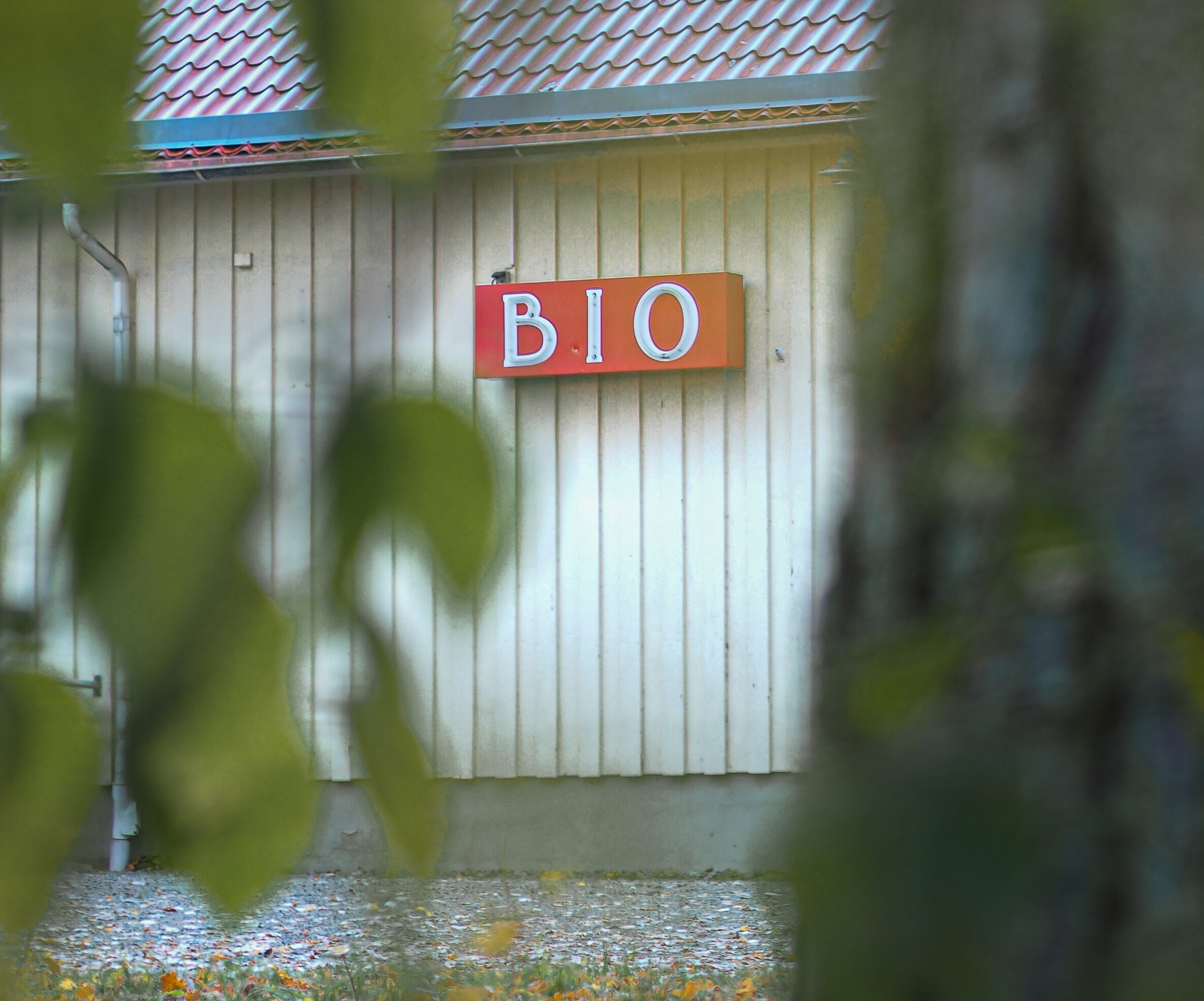 En närbild på en neonröd bioskylt på en husvägg.