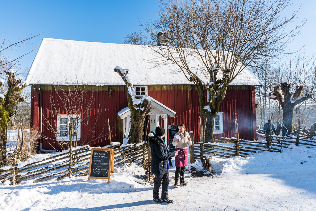 Ett rött torp i ett vinterlandskap.