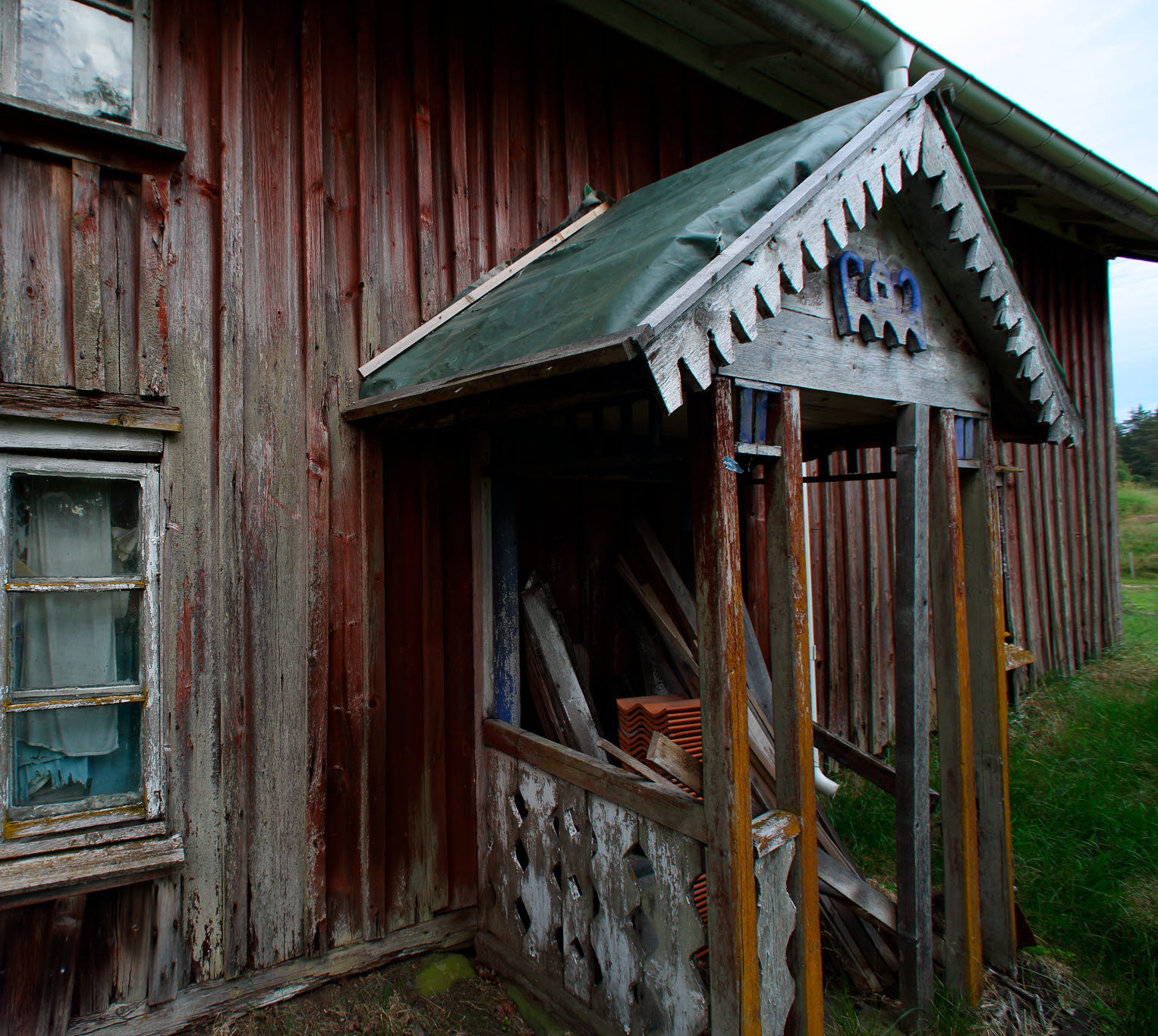 En röd gammal stuga som är förfallen.