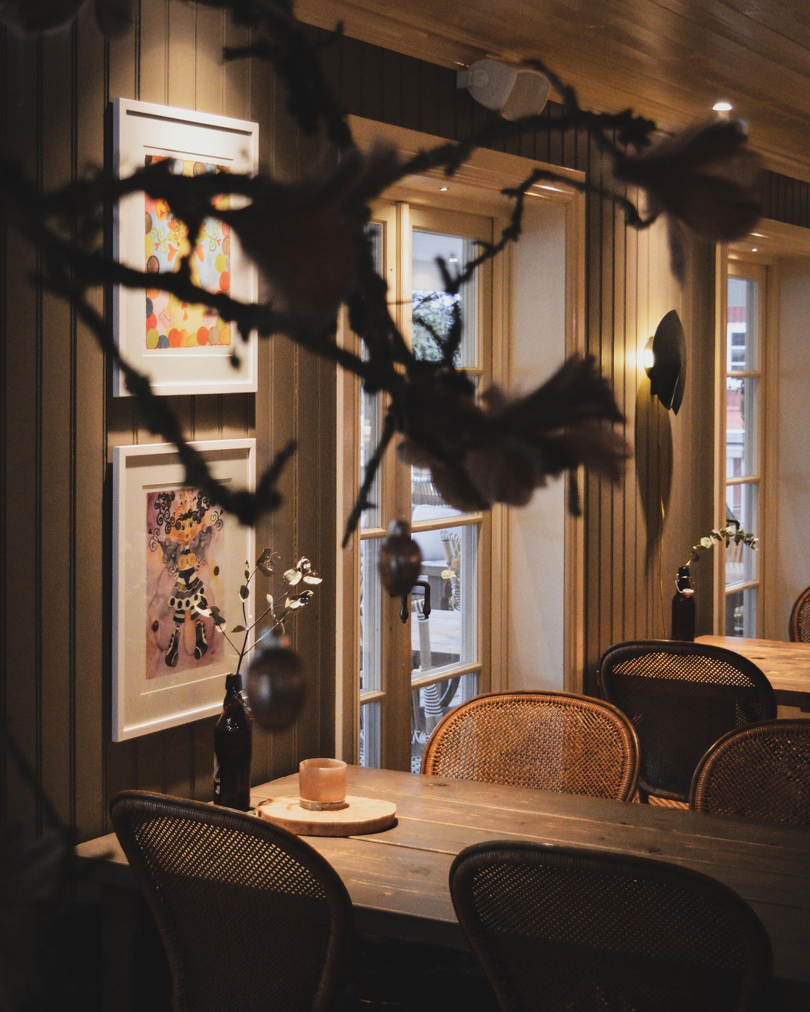 En bild från insidan på ett café där ett fikabord med stolar vid ett fönster.