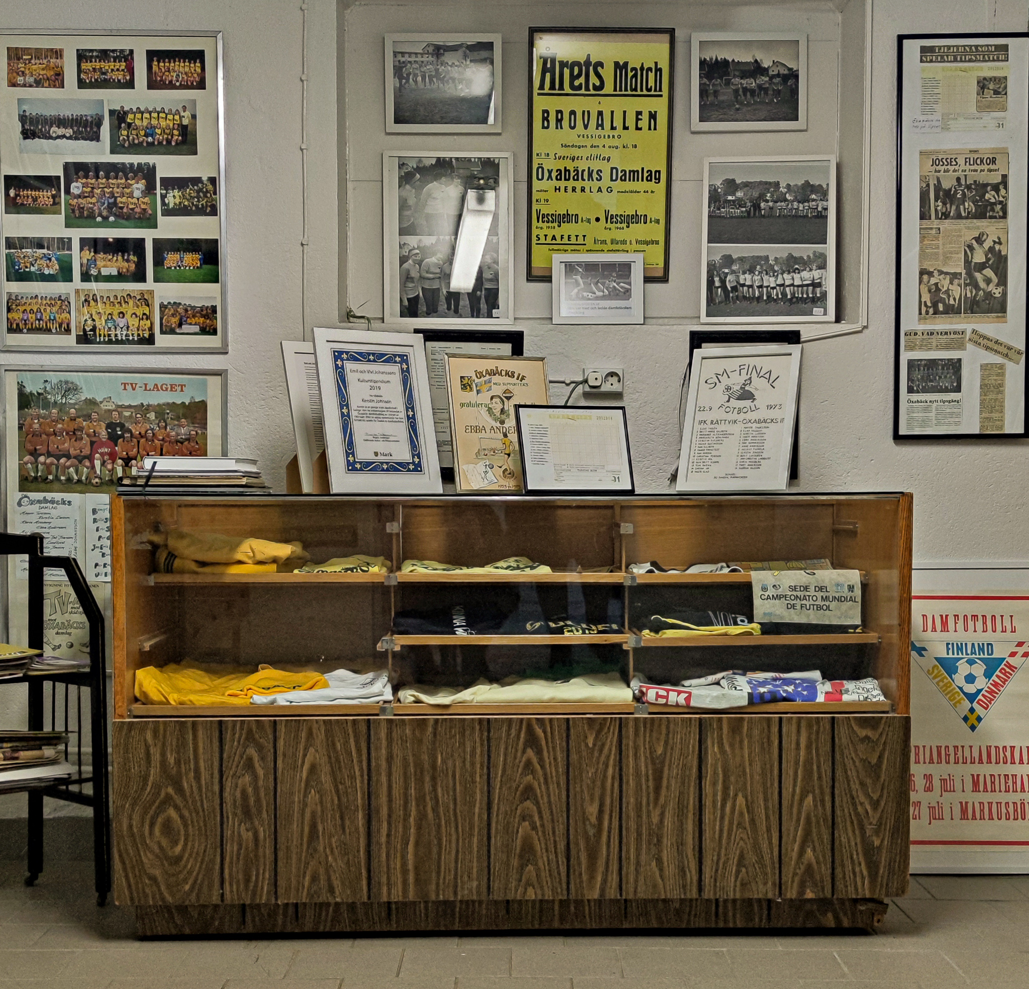 En närbild en köpmansdisk med saker i. På väggarna hänger mängder av fotografier, tidningsartiklar och tavlor.